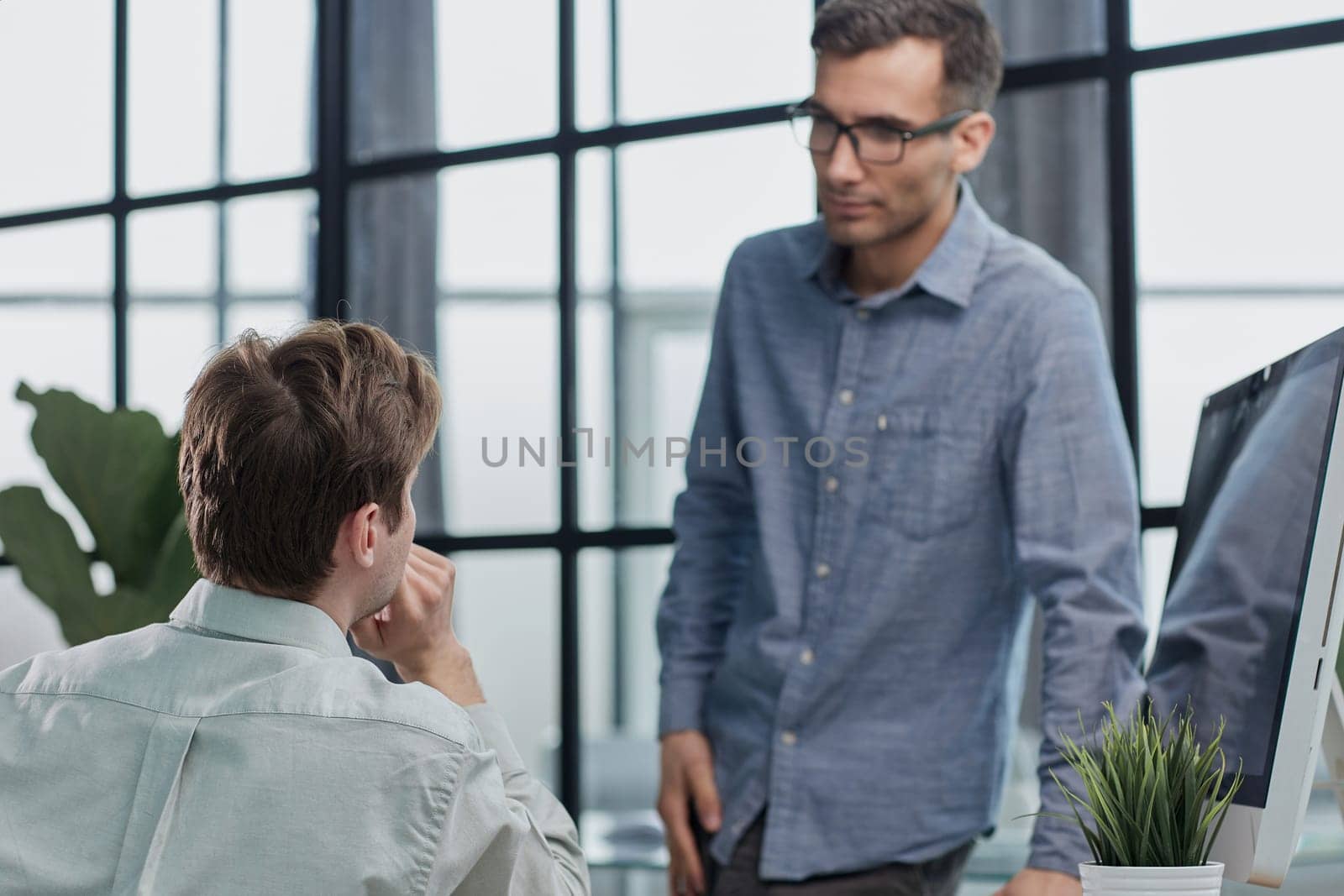Mature businessman to discuss information with a younger colleague in a modern business lounge