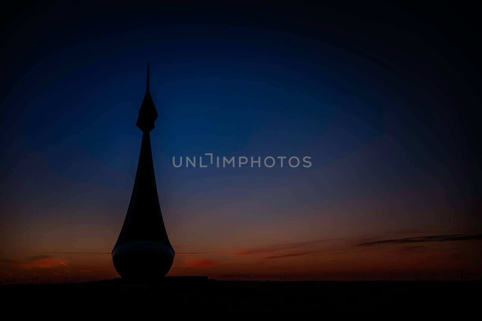 a buoy on the field in groningen during sunset with red and blue sky