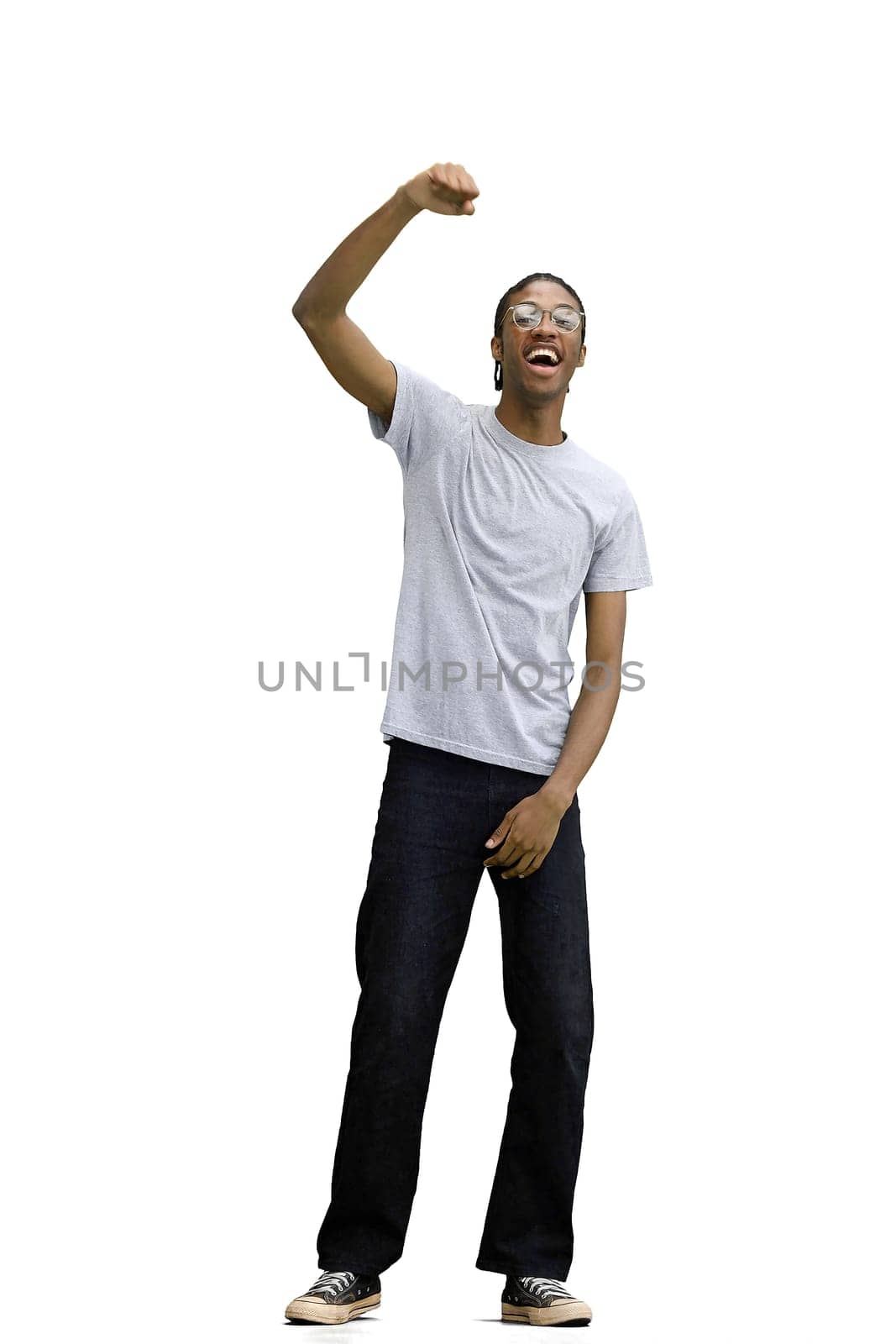 A man in a gray T-shirt, on a white background, in full height, rejoices.