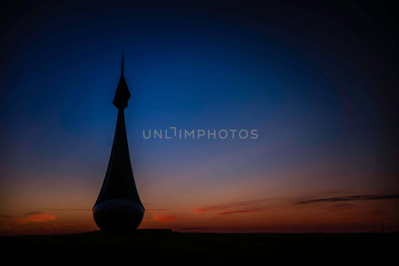 a buoy on the field in groningen during sunset with red and blue sky