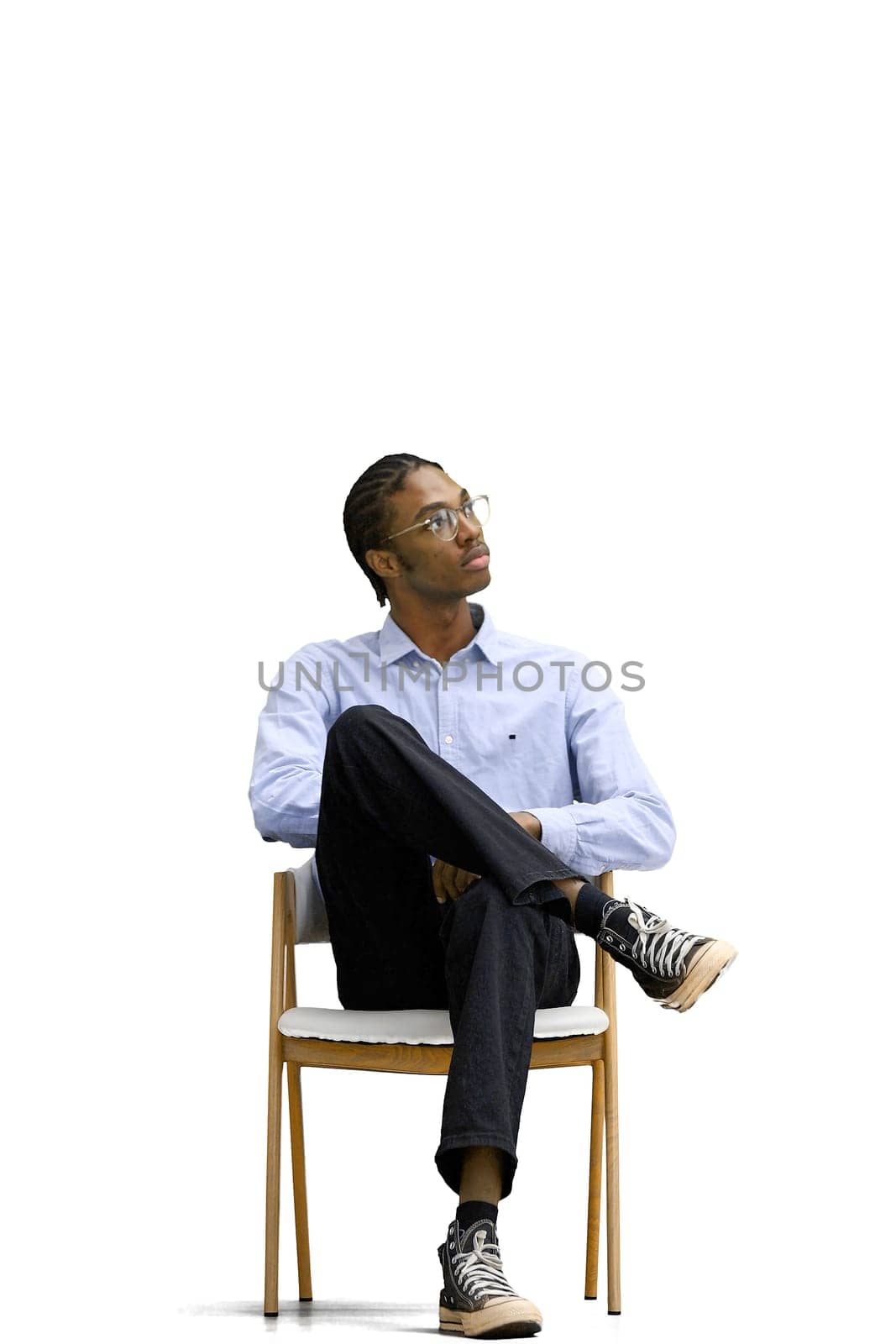 A man in a gray shirt, on a white background, is sitting on a chair by Prosto