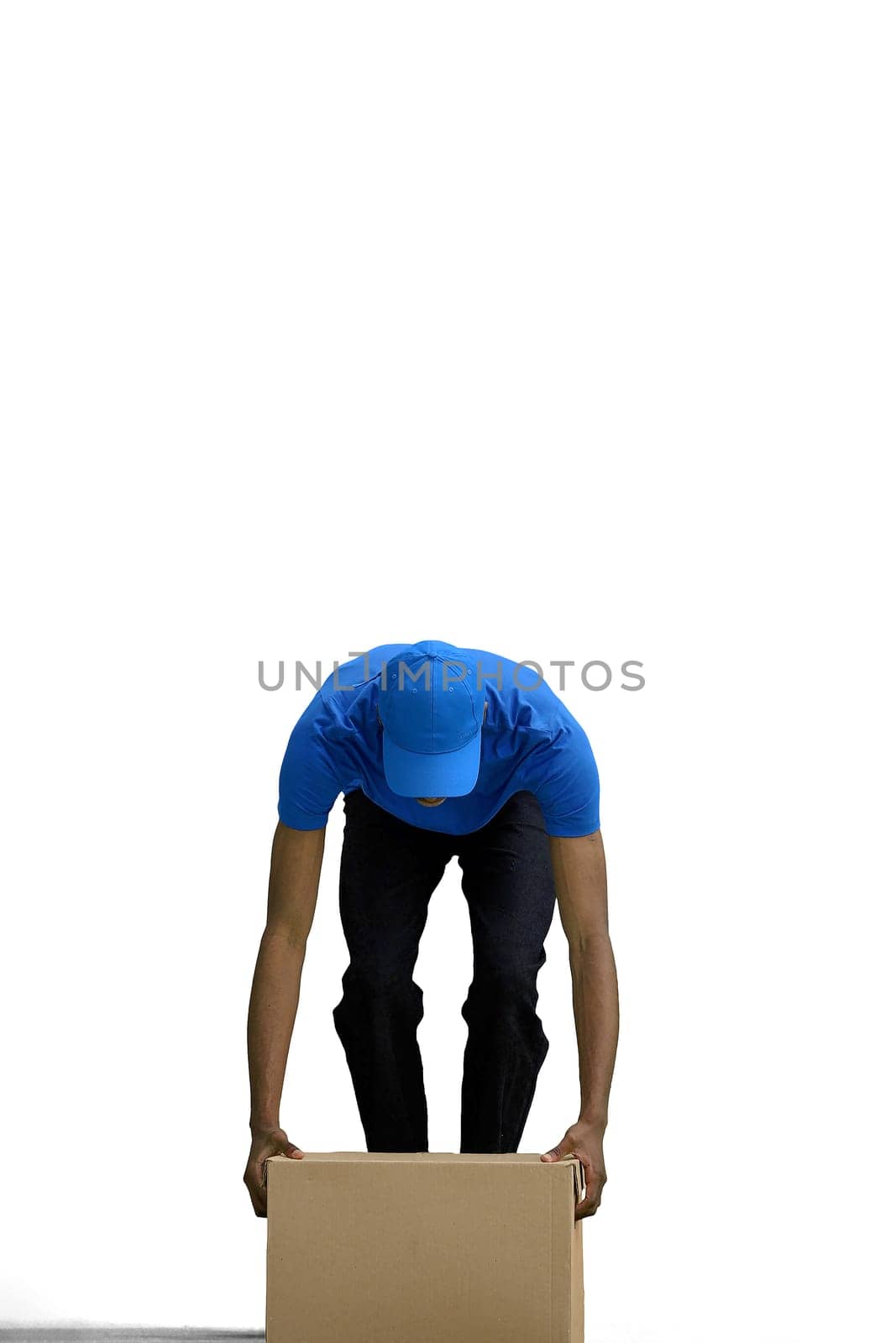 A male deliveryman, on a white background, in full height, put down a box.