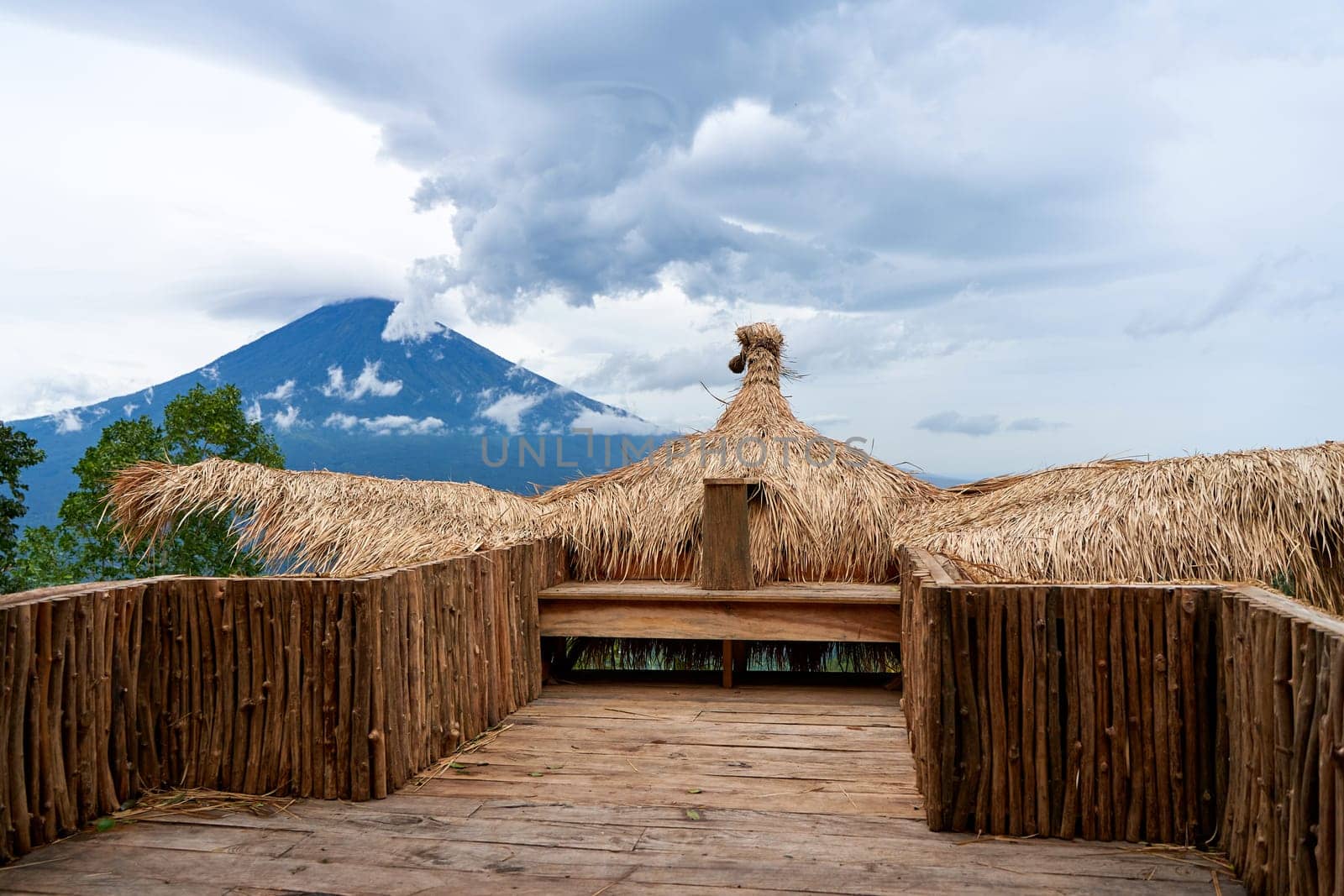 A large straw photo zone - a bird on a viewpoint overlooking the sacred volcano Agung, hidden by clouds on a rainy day on the island of Bali