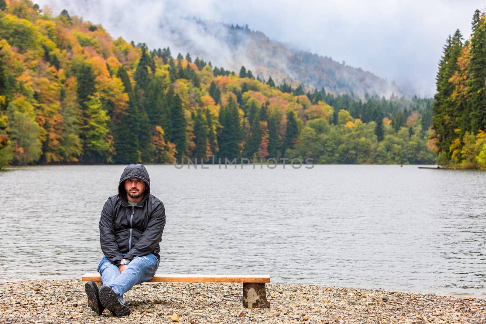 Man on the shore of a lake in the mountains by Yurich32