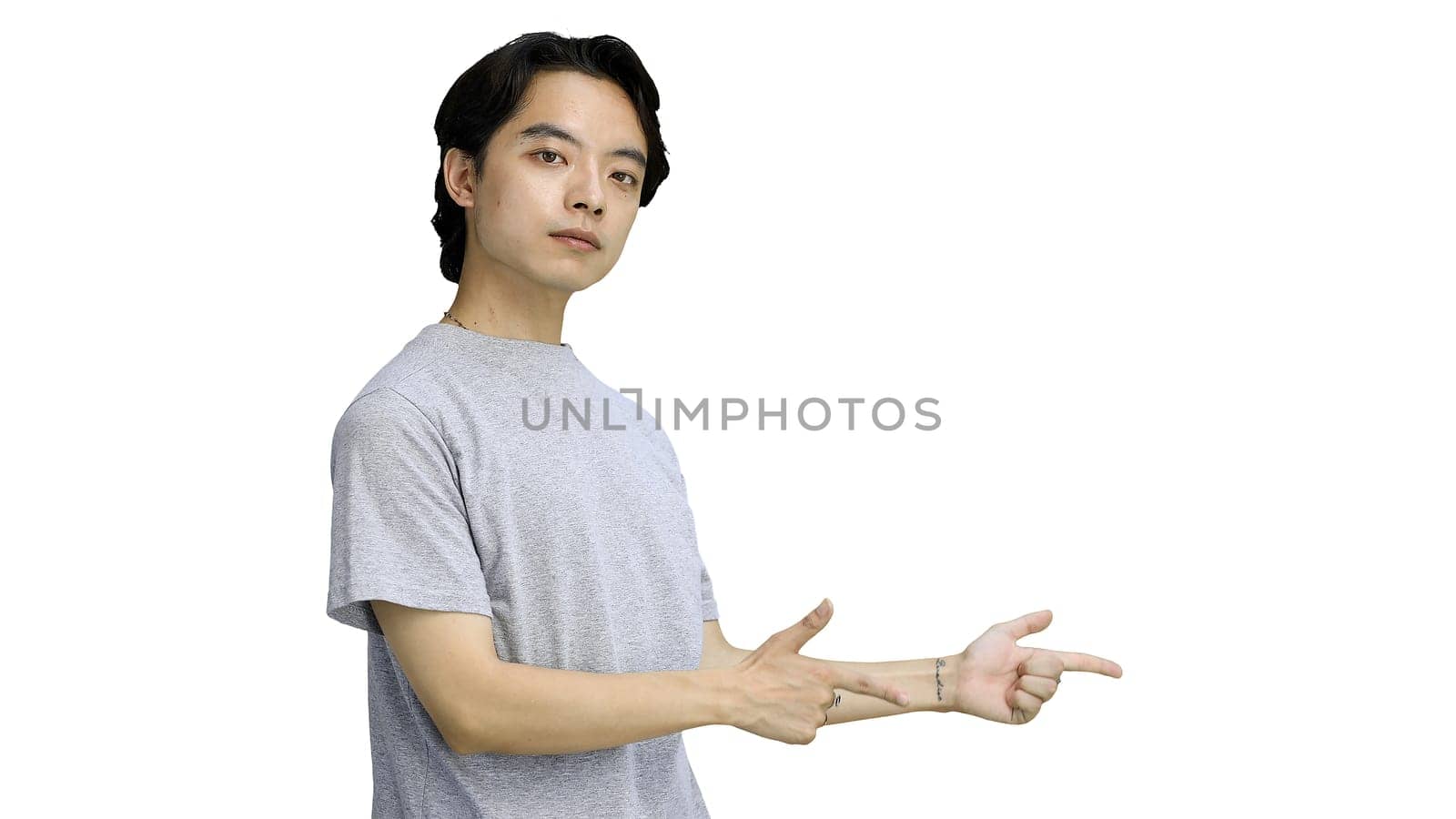 A guy in a gray T-shirt, on a white background, close-up, pointing side.