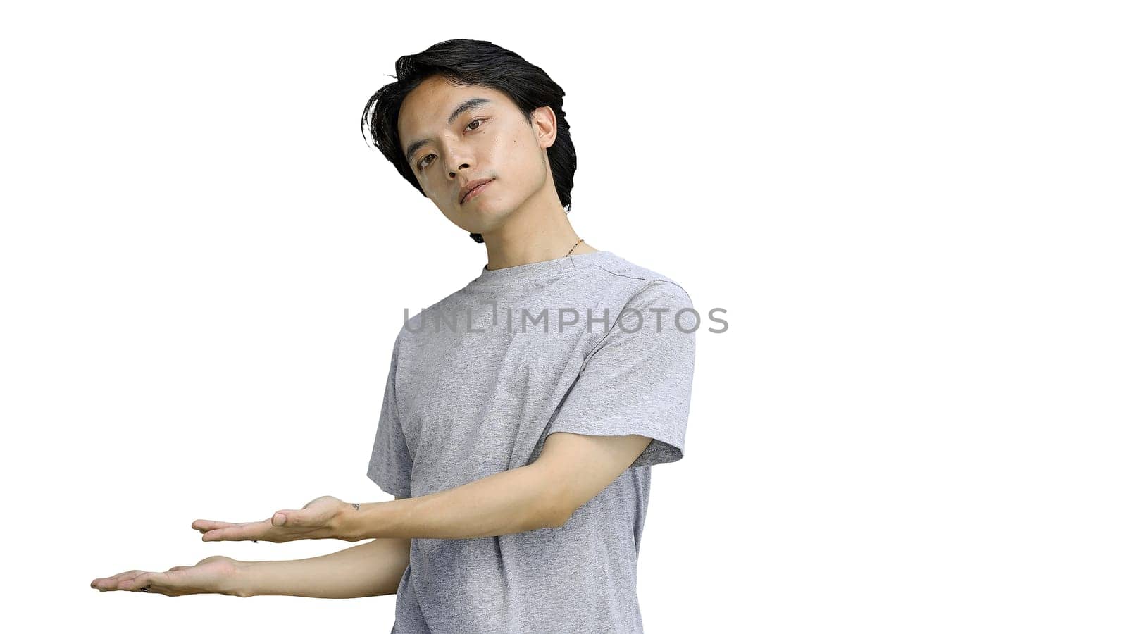 A guy in a gray T-shirt, on a white background, close-up, pointing side.