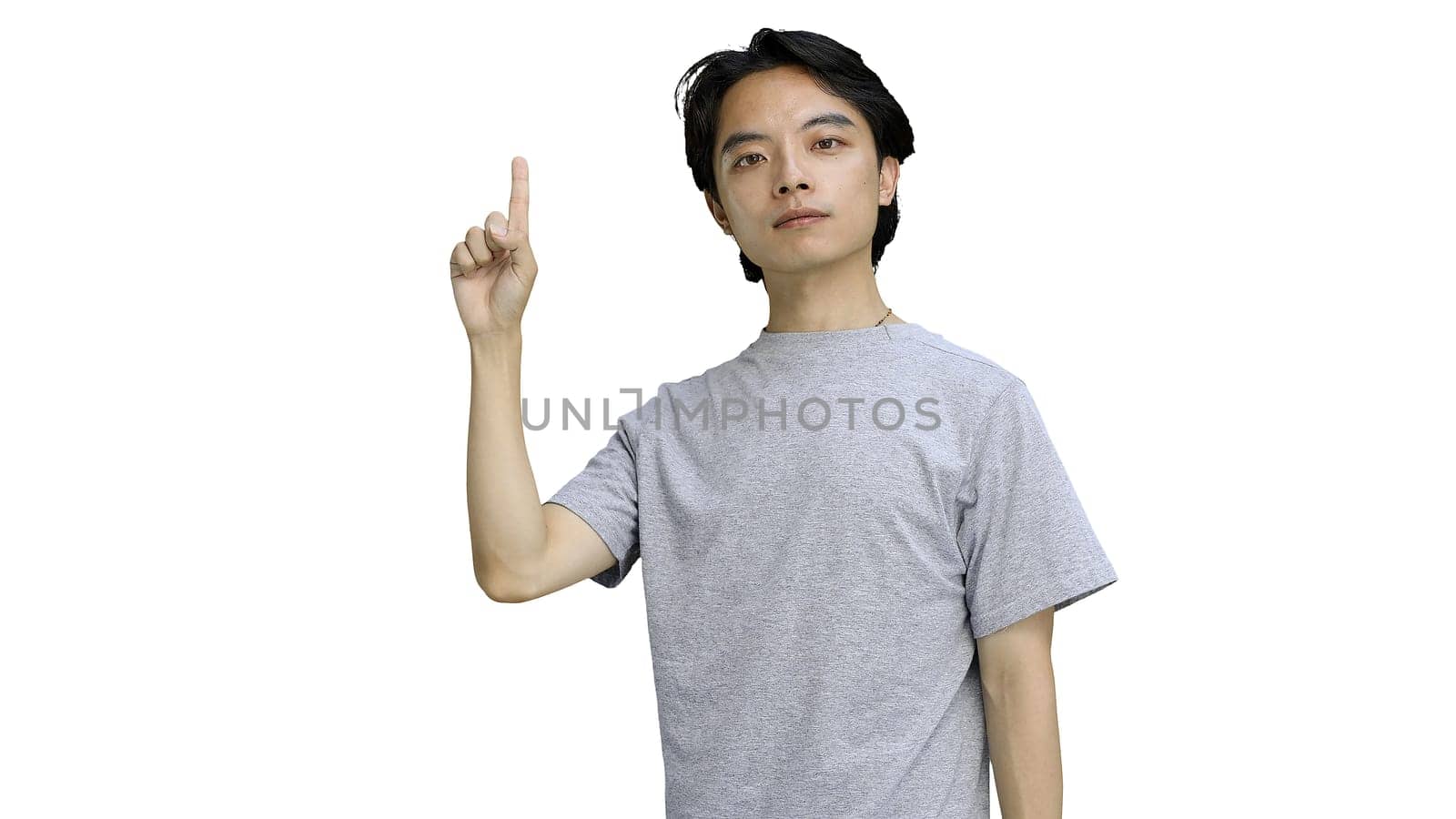 Guy in a gray T-shirt, on a white background, close-up, pointing up.