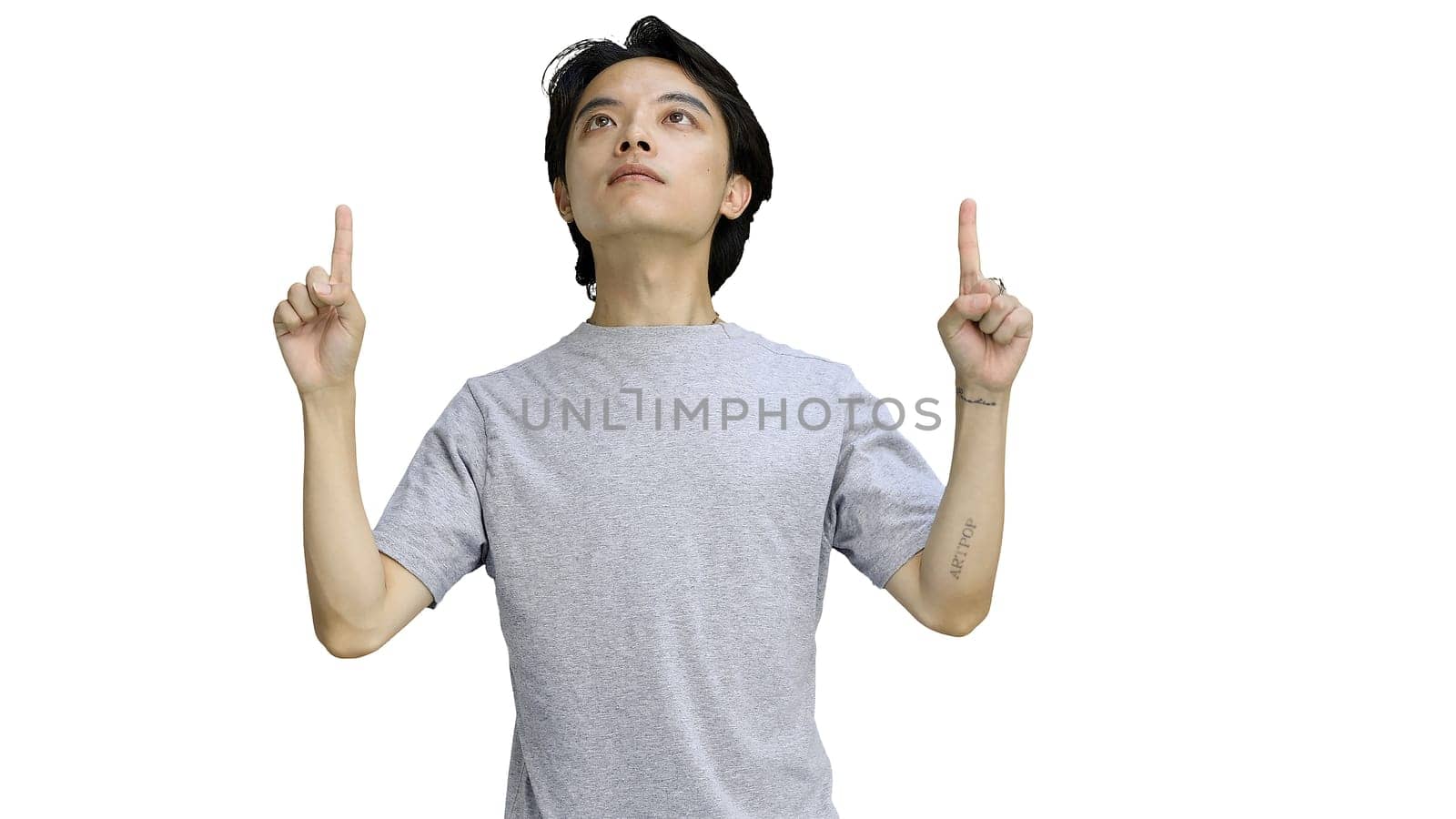 Guy in a gray T-shirt, on a white background, close-up, pointing up.