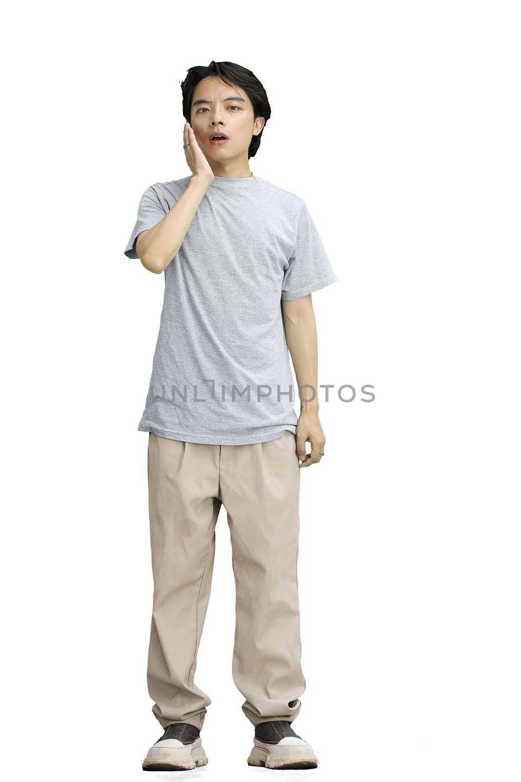 A guy in a gray T-shirt, on a white background, in full height, yawns by Prosto