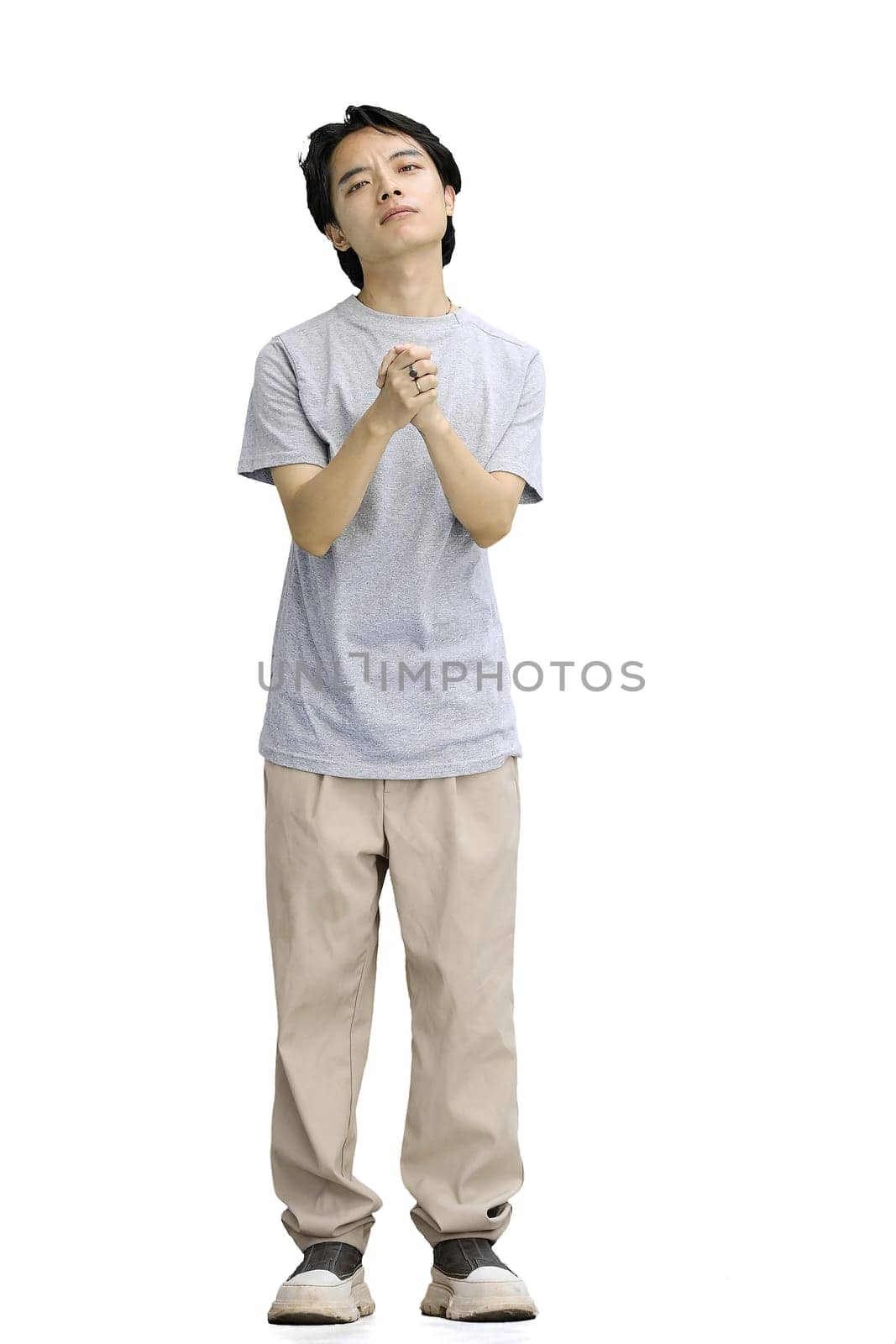 A guy in a gray T-shirt, on a white background, full-length, begging.