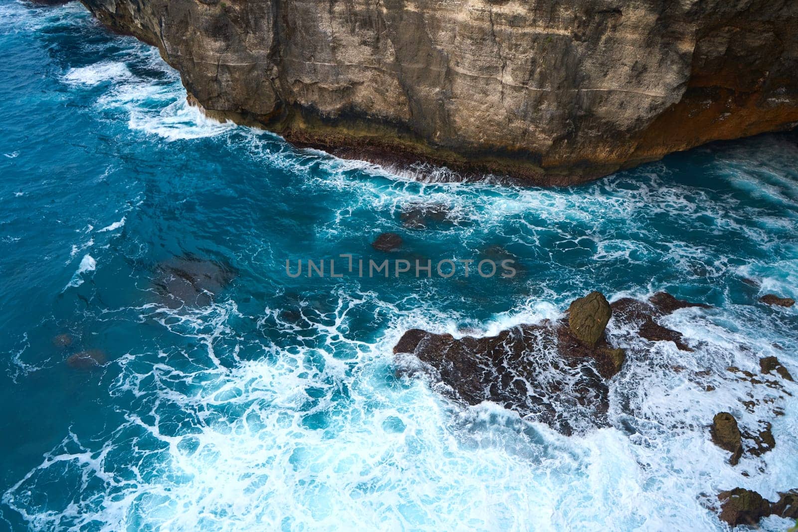Cinematic aerial landscape shots of the beautiful island of Nusa Penida. Huge cliffs by the shoreline and hidden dream beaches with clear water and foaming wave