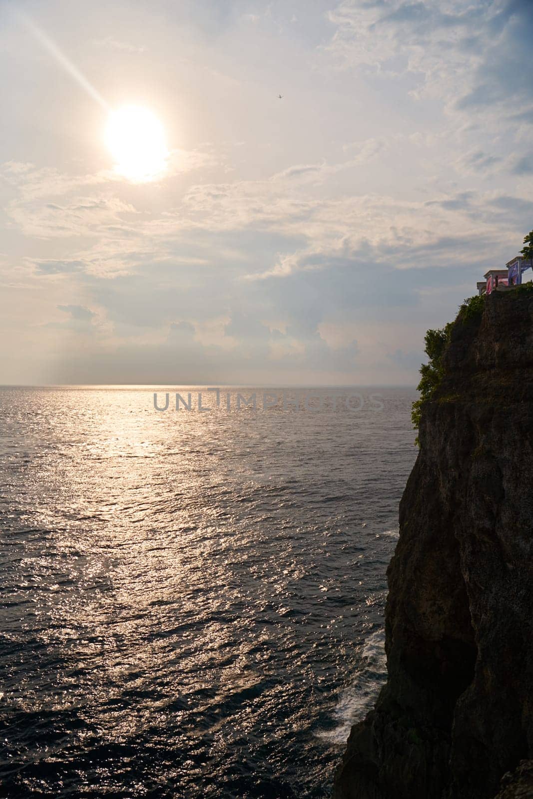 The view of the mountain and the ocean at sunset. A sunny path over the sea