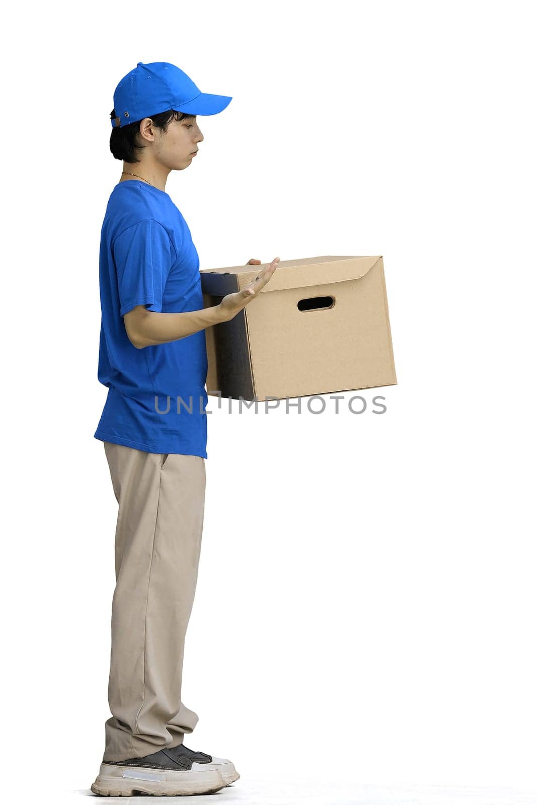 The delivery guy, on a white background, in full height, points to the box.