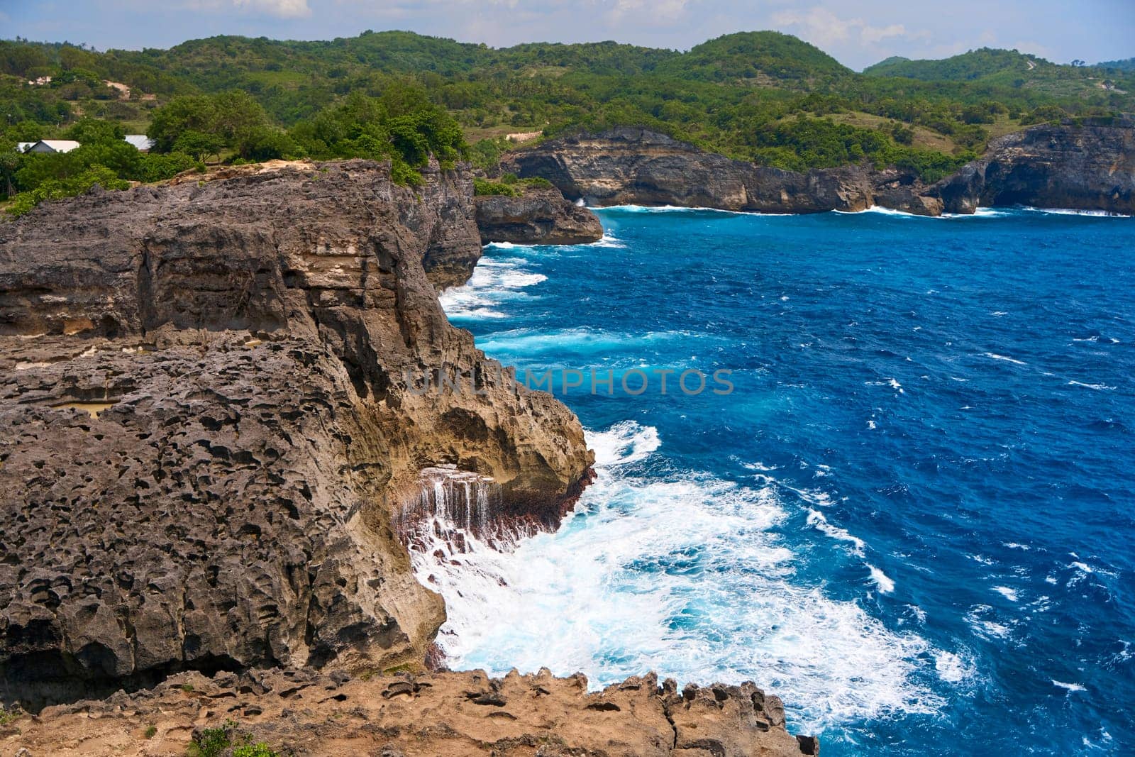 Cinematic aerial landscape shots of the beautiful island of Nusa Penida. Huge cliffs by the shoreline and hidden dream beaches with clear water and foaming wave