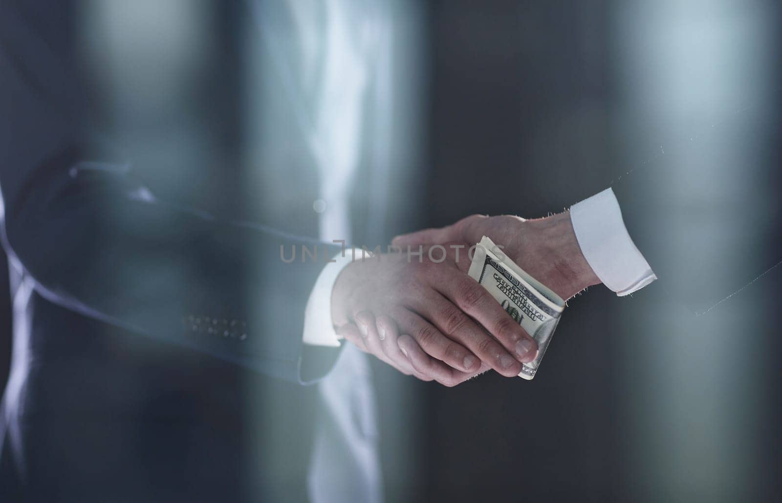 businessman hand giving money on black background by Prosto