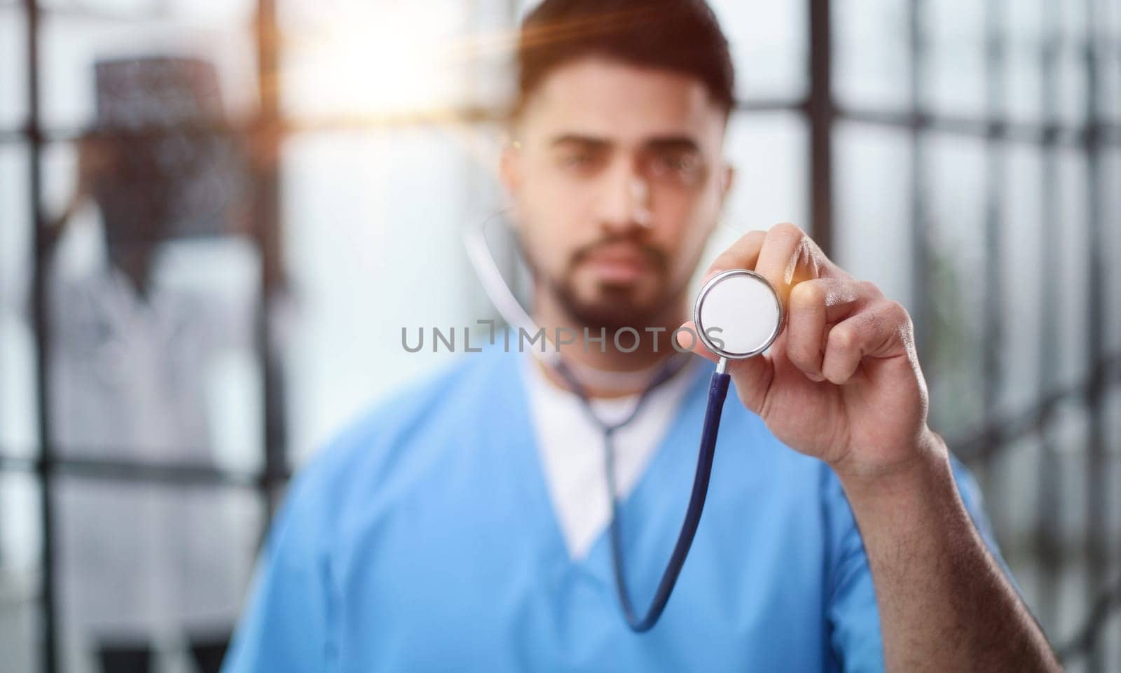 healthcare and medicine - doctor in blue coat holding stethoscope by Prosto