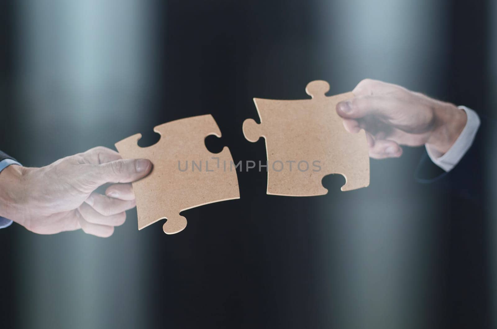 Hand holds mosaic puzzles on black background close-up. business planning teamwork concept of help strategy and success