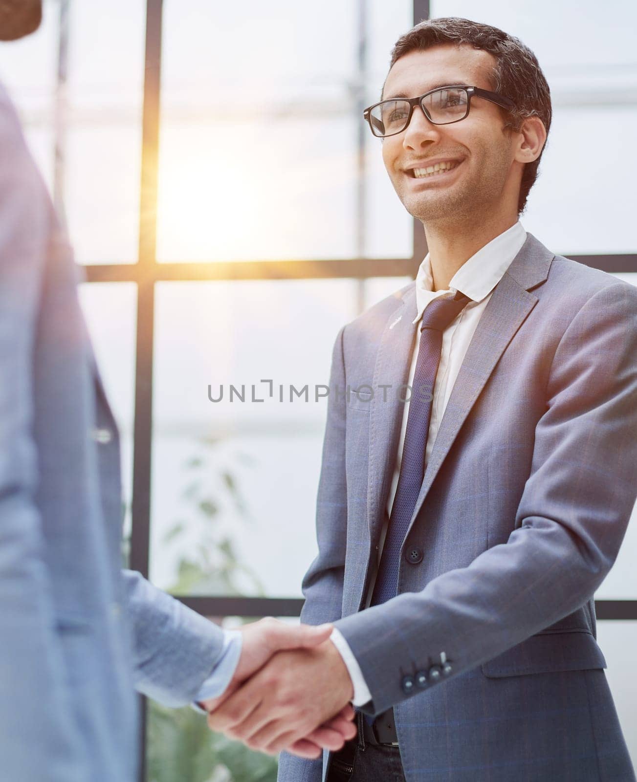 Two business men shaking hands together after successful meeting. by Prosto