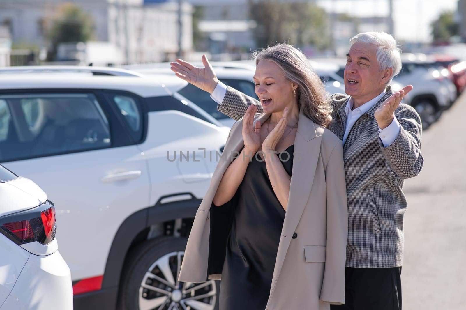 An elderly Caucasian man gives a new car to his beloved woman