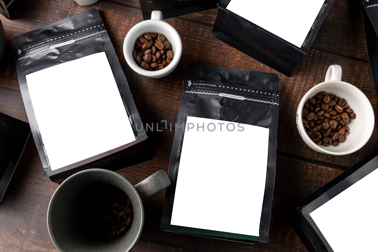 Black coffee foil packaging bag with blank white label on wooden table by Sonat