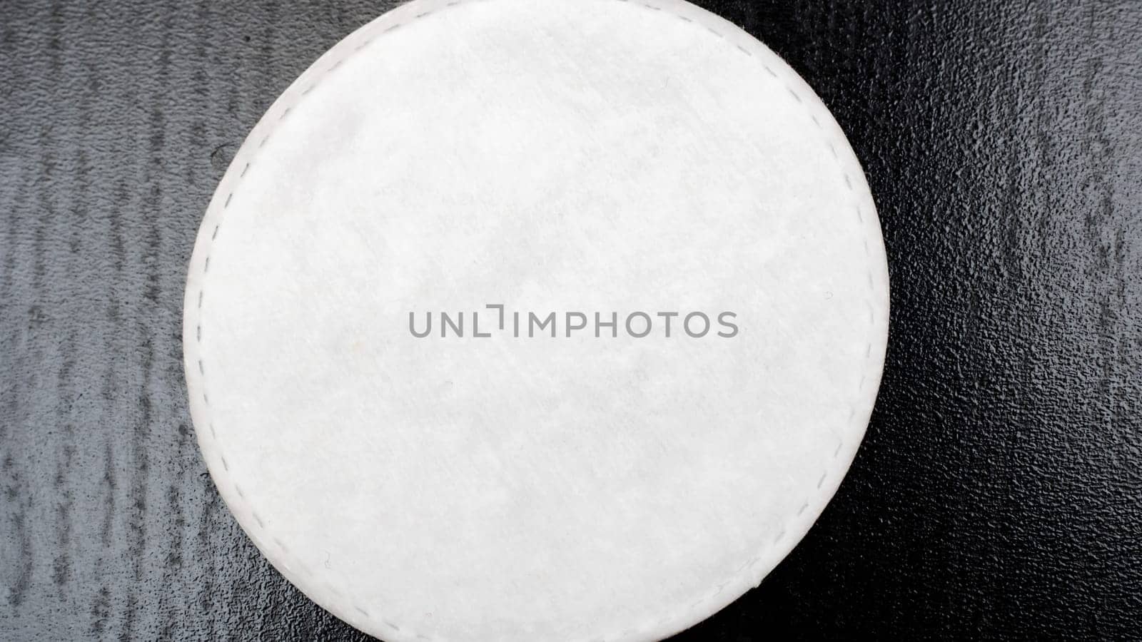 Cotton pads on a black table close up, copy space