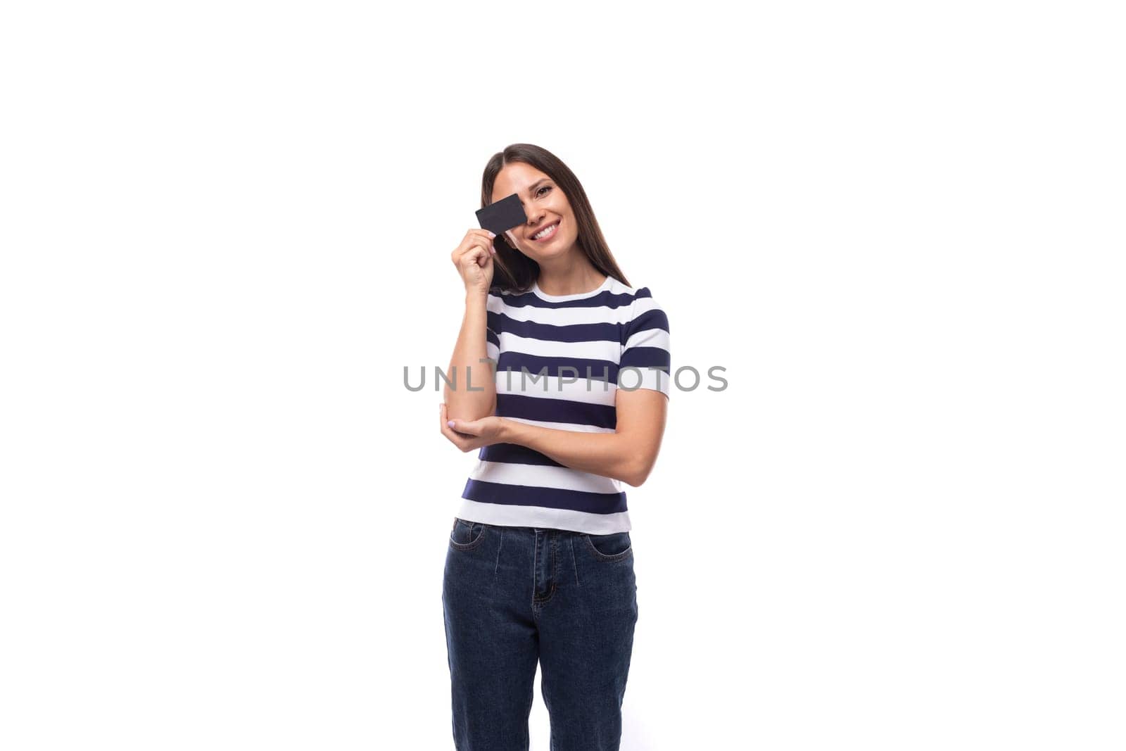 confident young caucasian brunette woman in a striped black and white t-shirt shows a plastic card mockup by TRMK