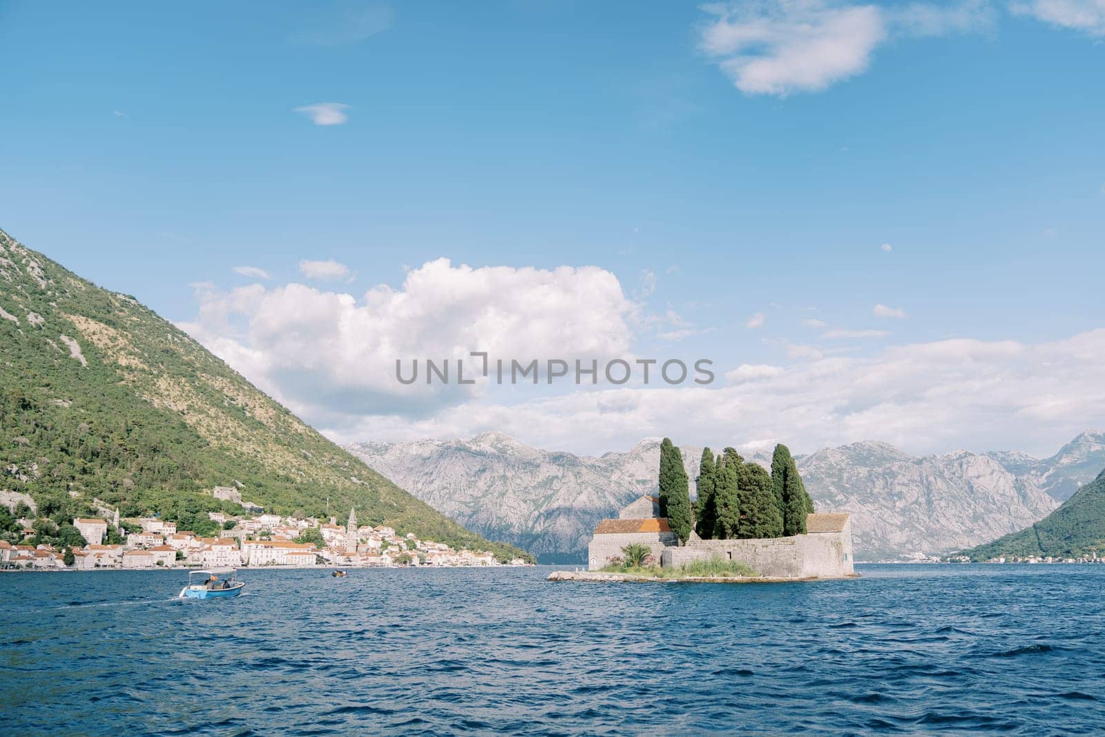 Island of St. George in the Bay of Kotor against the background of the coast of Perast at the foot of the mountains. Montenegro. High quality photo
