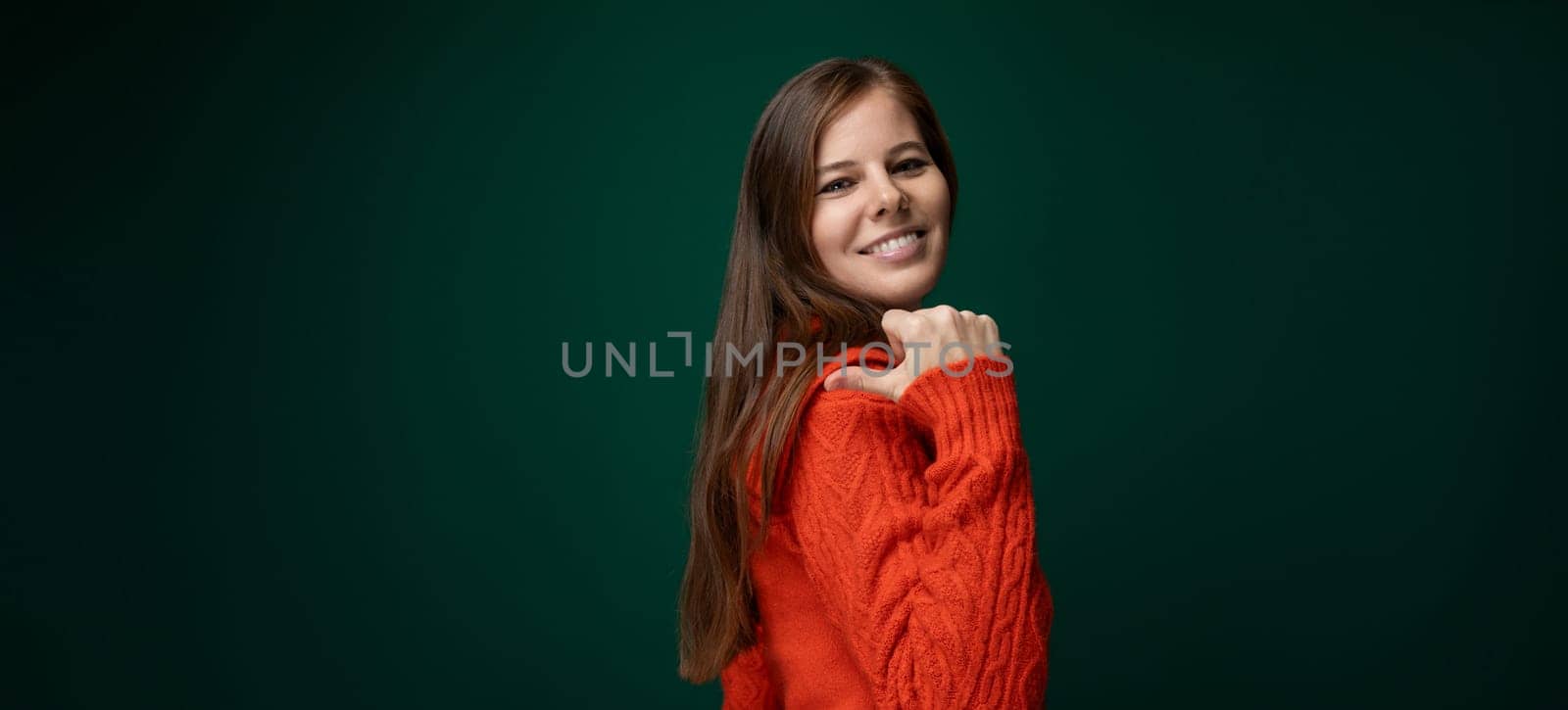 Cheerful 30 year old woman with brown hair points with her hand to the news by TRMK