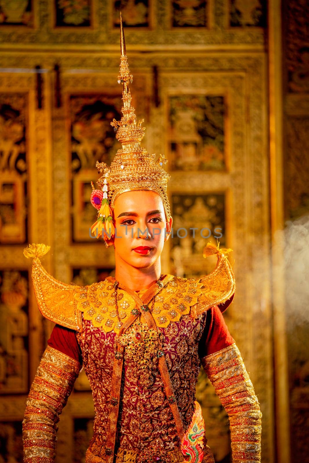 Portrait of Khon or traditional Thai classic masked from the Ramakien with man wear beautiful traditional dress and Thai paintings background in a public place.