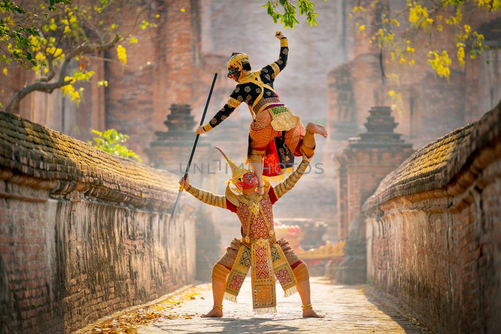 Khon or traditional Thai classic masked from the Ramakien characters action of traditional dance with fighting position and Thai ancient building as background in public place.