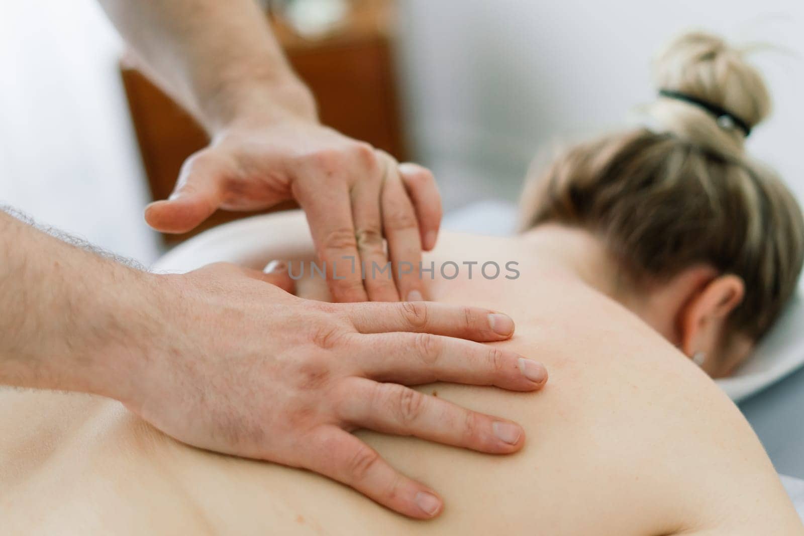Young fat woman getting massage treatment in a day spa cabinet.