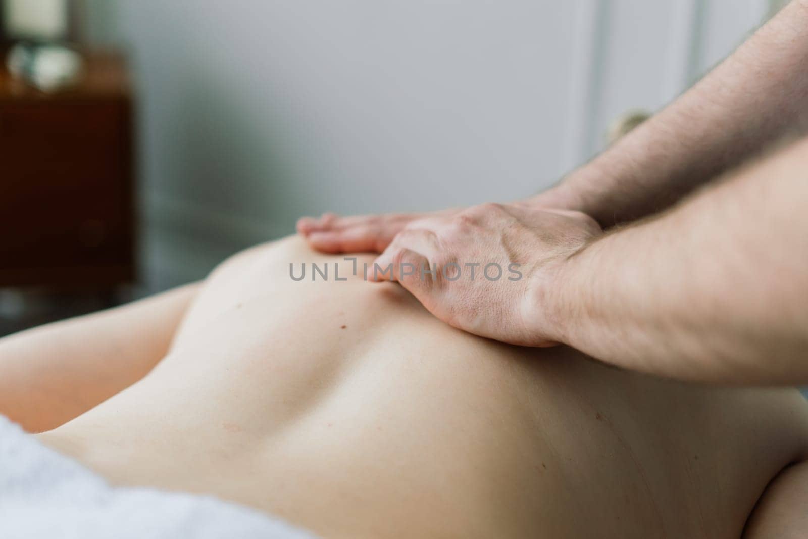 Young fat woman getting massage treatment in day spa cabinet. by Zelenin