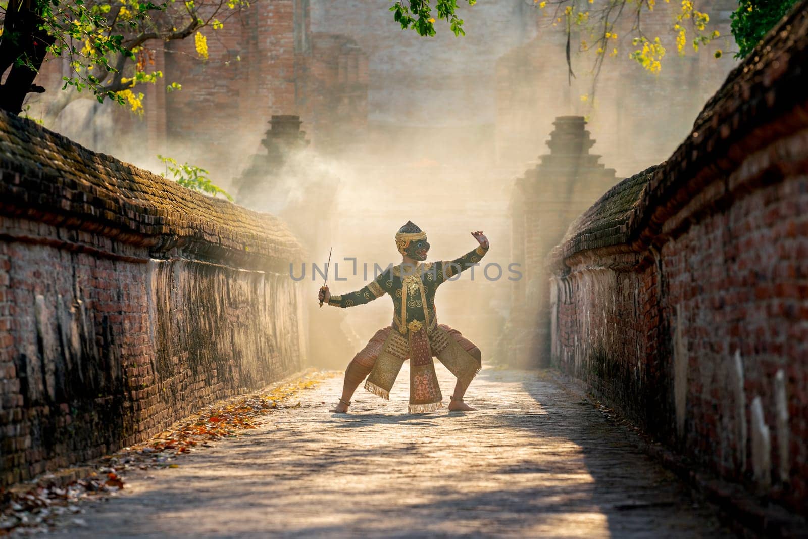 Khon or traditional Thai classic masked from the Ramakien characters as black monkey dance in front of ancient building and stay on the way of old wall.