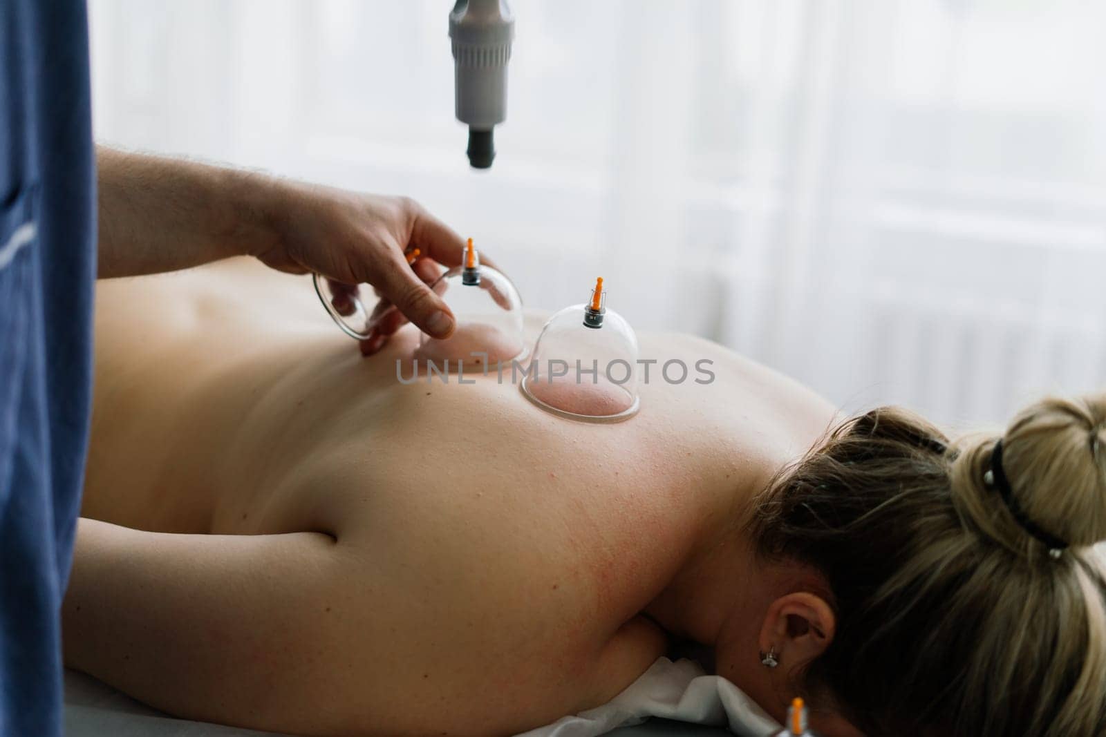 Young fat woman getting massage treatment in day spa cabinet. by Zelenin
