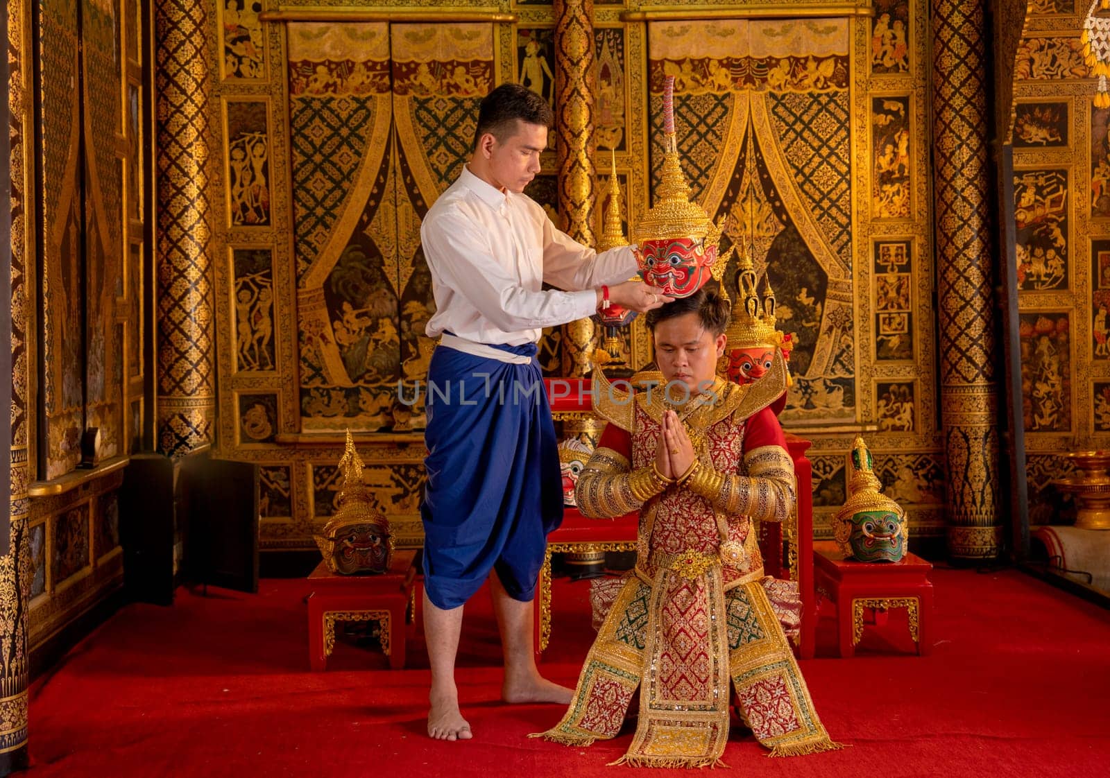 Asian man with Thai style cloth hold Khon mask and stand with action for traditional ceremony of respect to teacher.