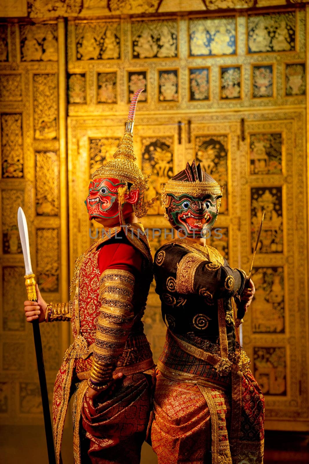 Khon or traditional Thai classic masked from the Ramakien with Red giant stand beside black monkey and Thai paintings background.