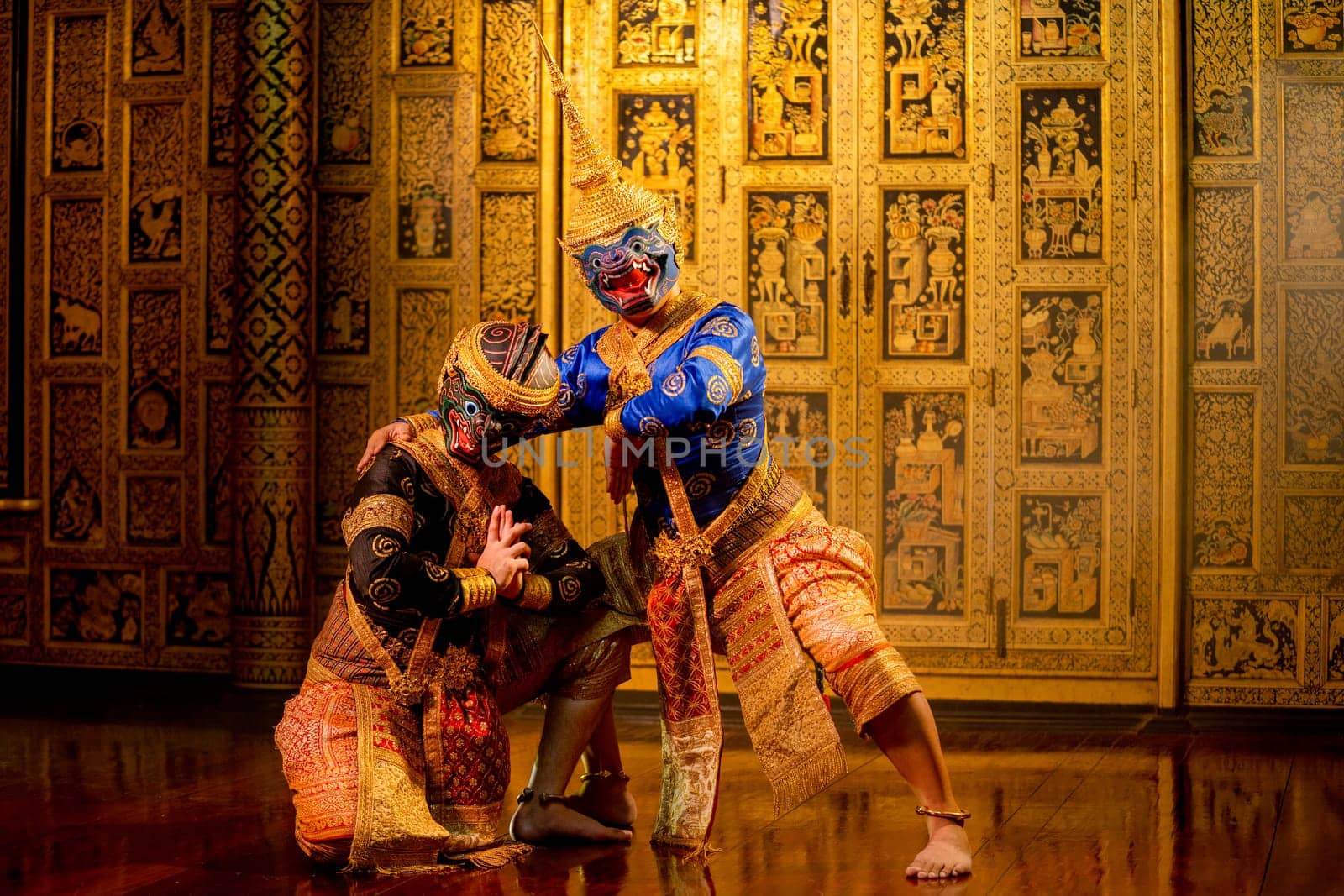 Khon or traditional Thai classic masked from the Ramakien with black and blue monkey stand together with action of traditional dance with Thai paintings background.