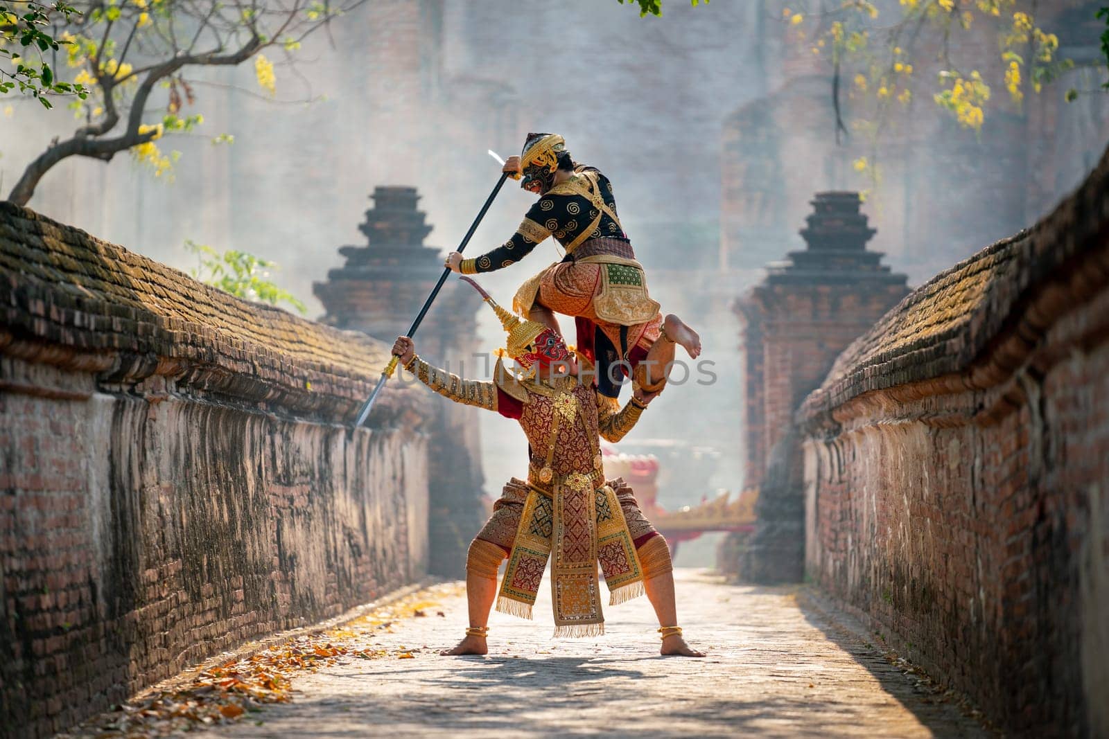 Khon or traditional Thai classic masked from the Ramakien characters action of traditional dance with fighting position and Thai ancient building in background.