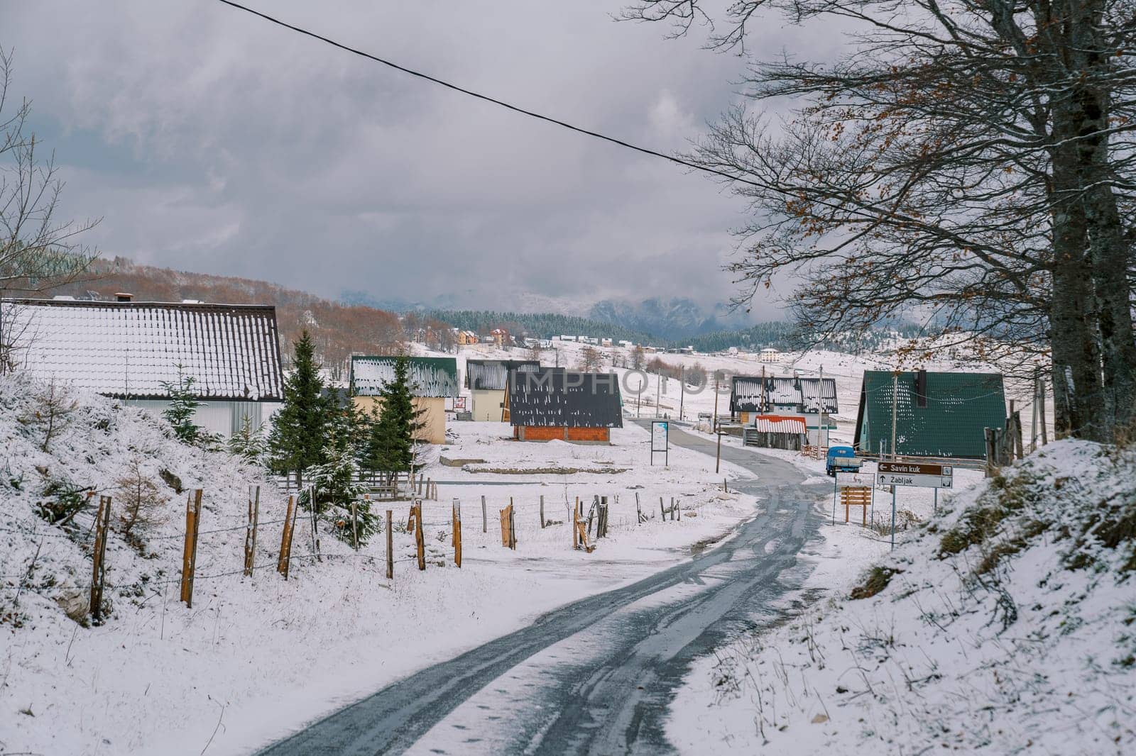 Snow-covered highway in a village with colorful houses in a mountain valley. High quality photo