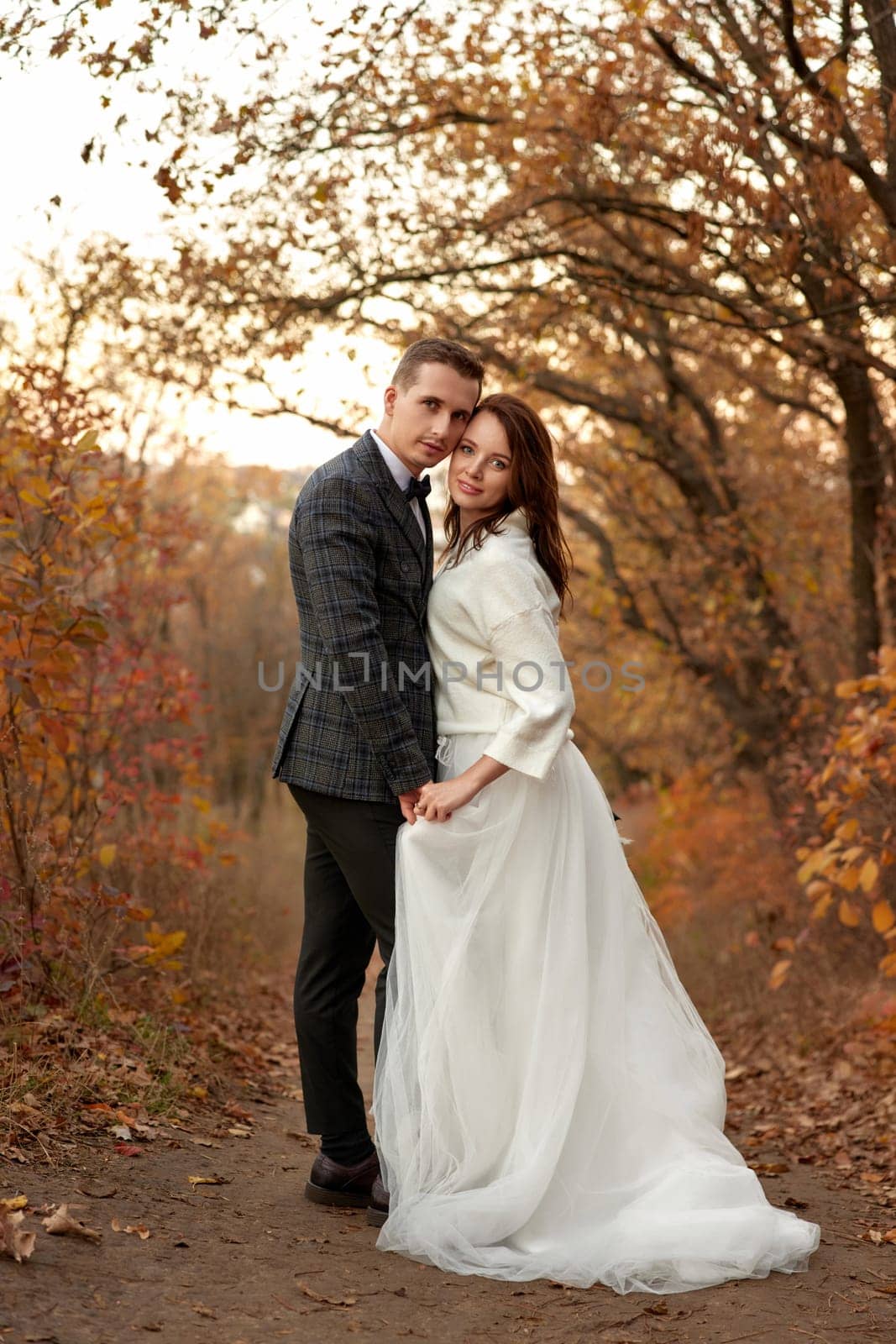 Newly married couple standing outdoor on natural background