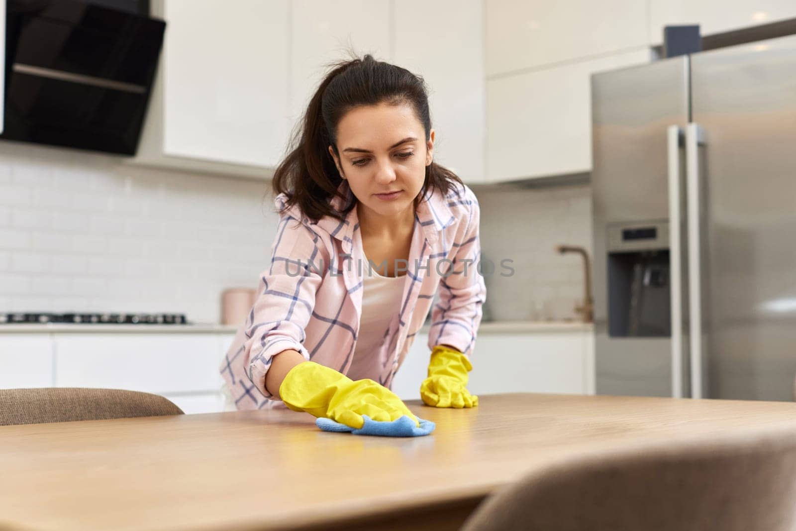 young woman cleaning wooden table with microfiber cloth. chores at home. Housekeeping