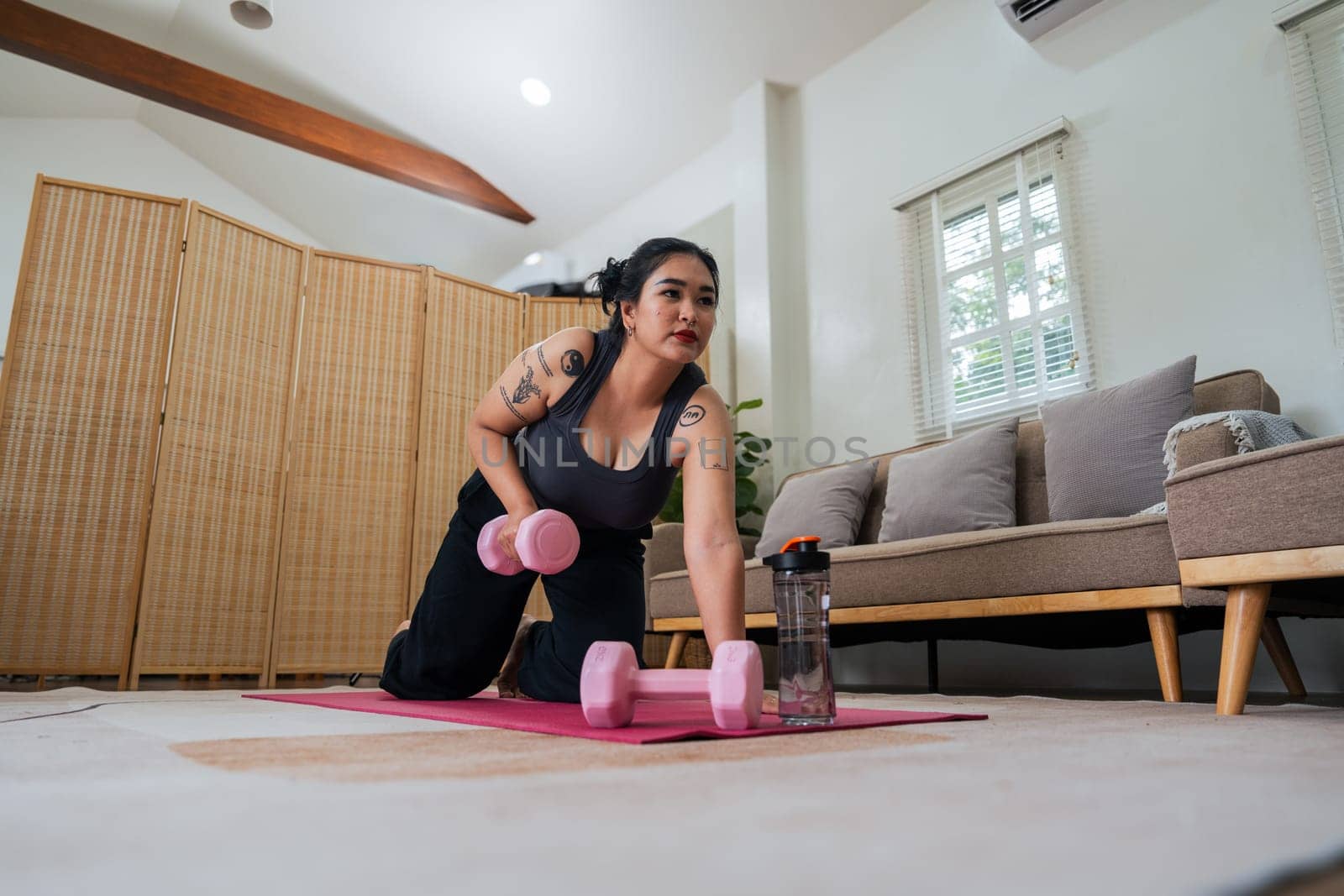 Happy fat overweight woman wearing sportswear doing fit exercise with dumbbells in living room at home. Workout sport, fitness and body concept by nateemee