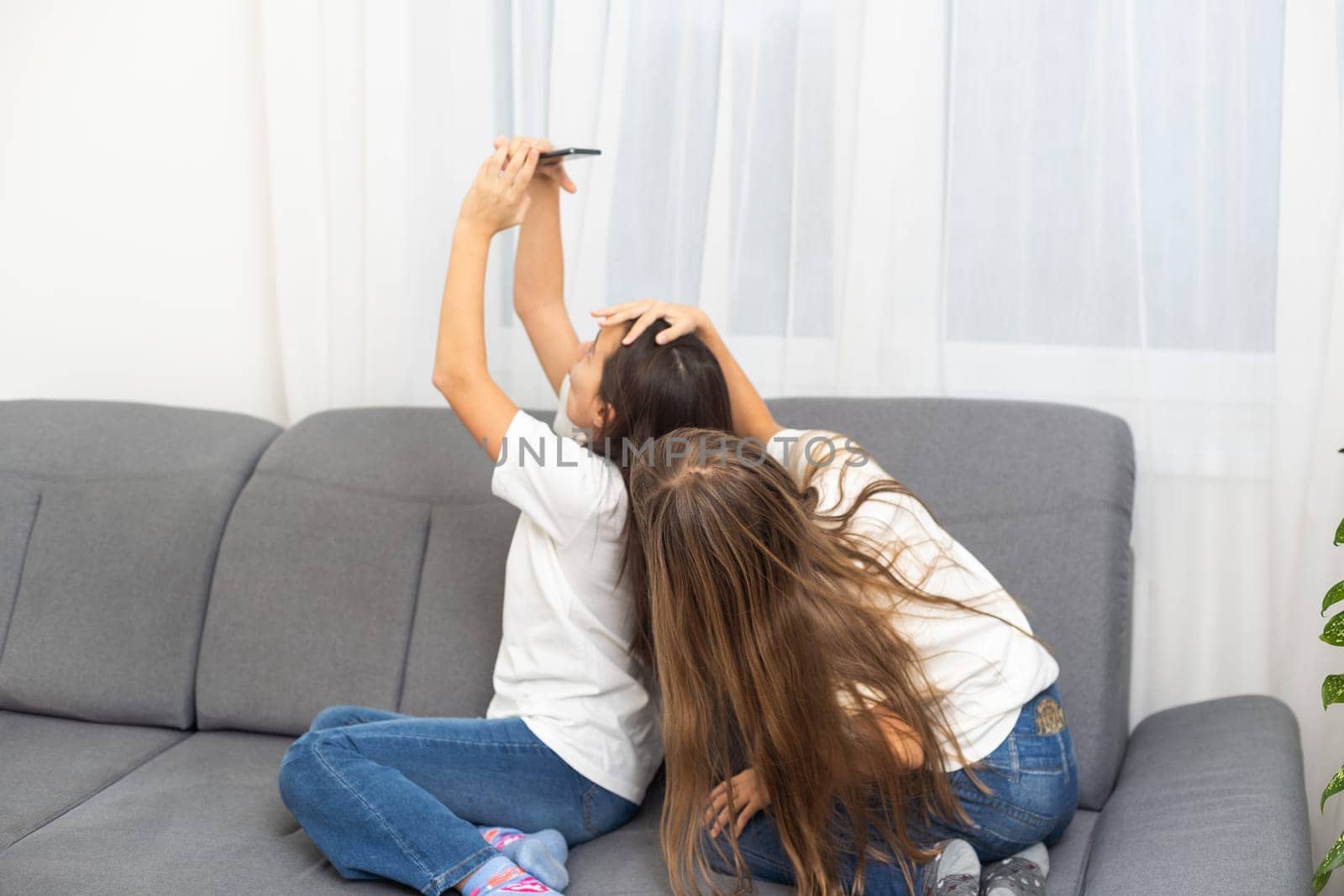 Children play with a mobile phone at home. High quality photo