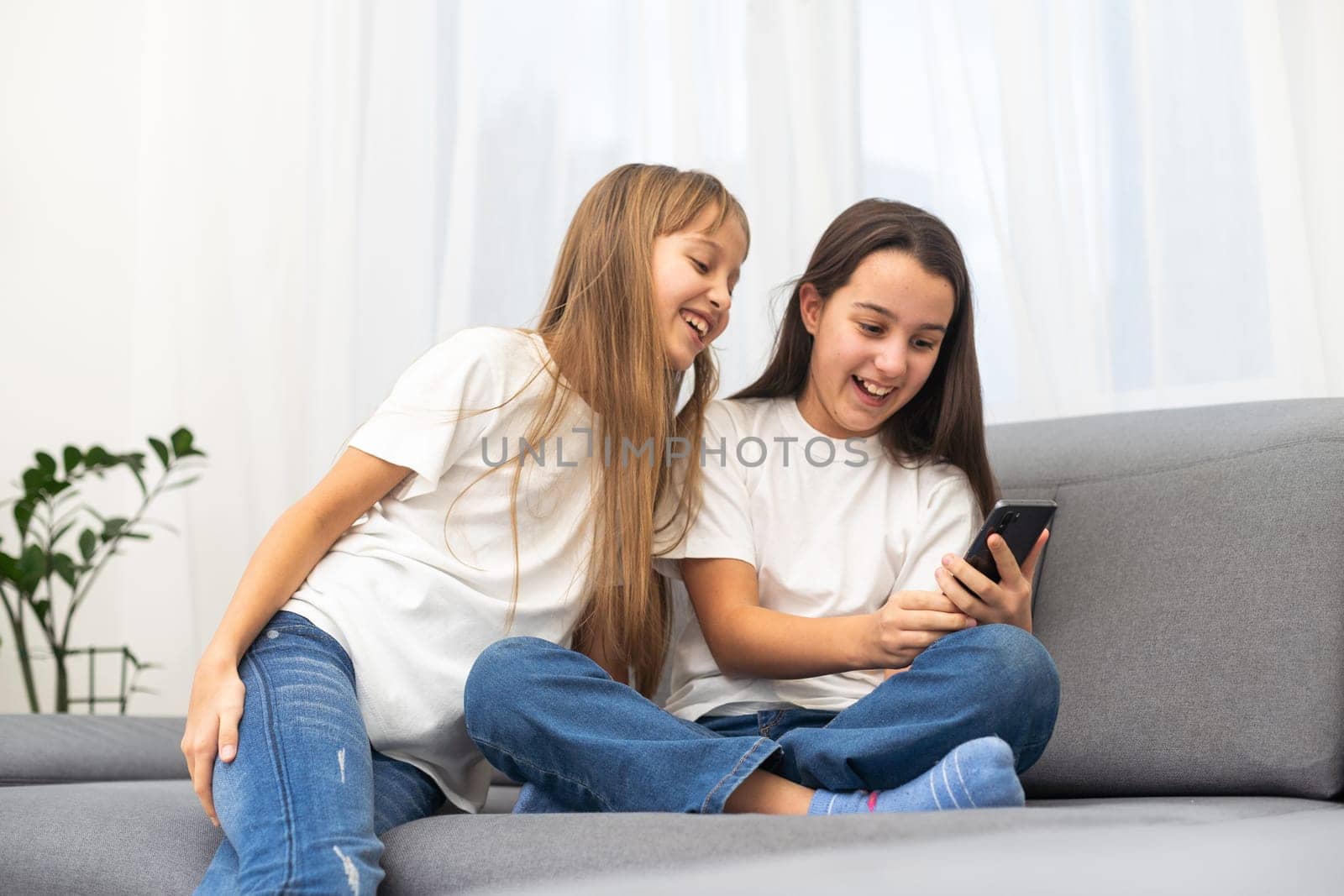Children play with a mobile phone at home. High quality photo