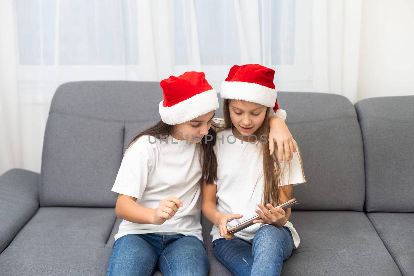 New year concept. christmas, x-mas, winter, happiness concept - two adorable cute girls playing with tablet pc by Andelov13