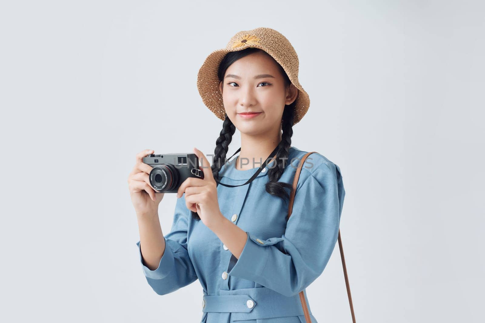 Beautiful and happy woman holding an old photography camera, isolated over a white background by makidotvn