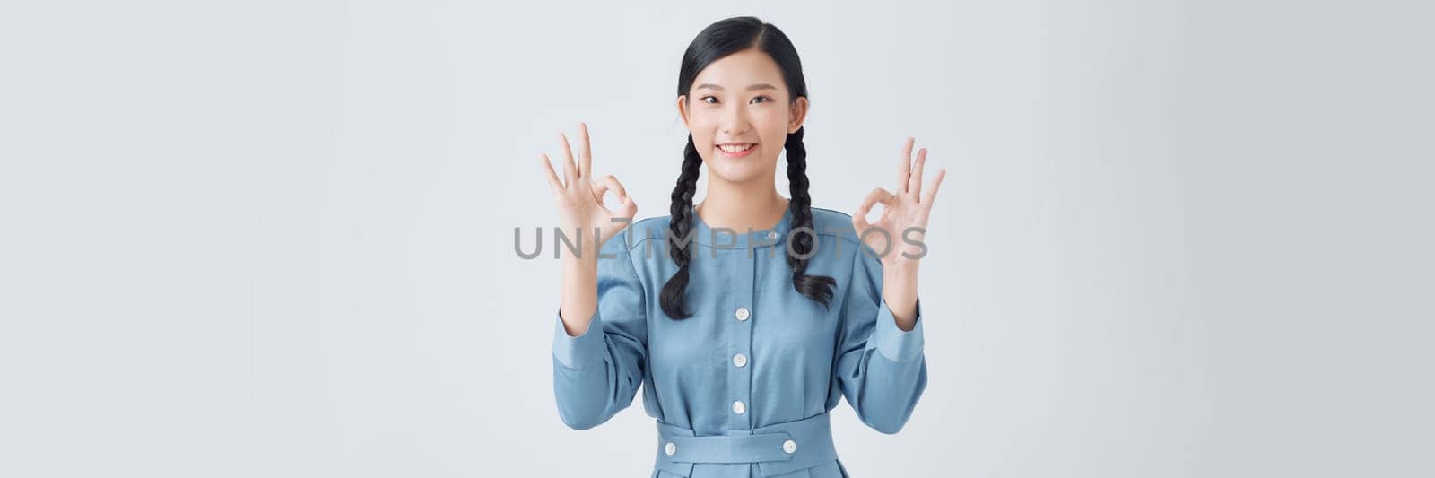 Pretty teen model lady showing okey symbol expressing agreement isolated on white background by makidotvn
