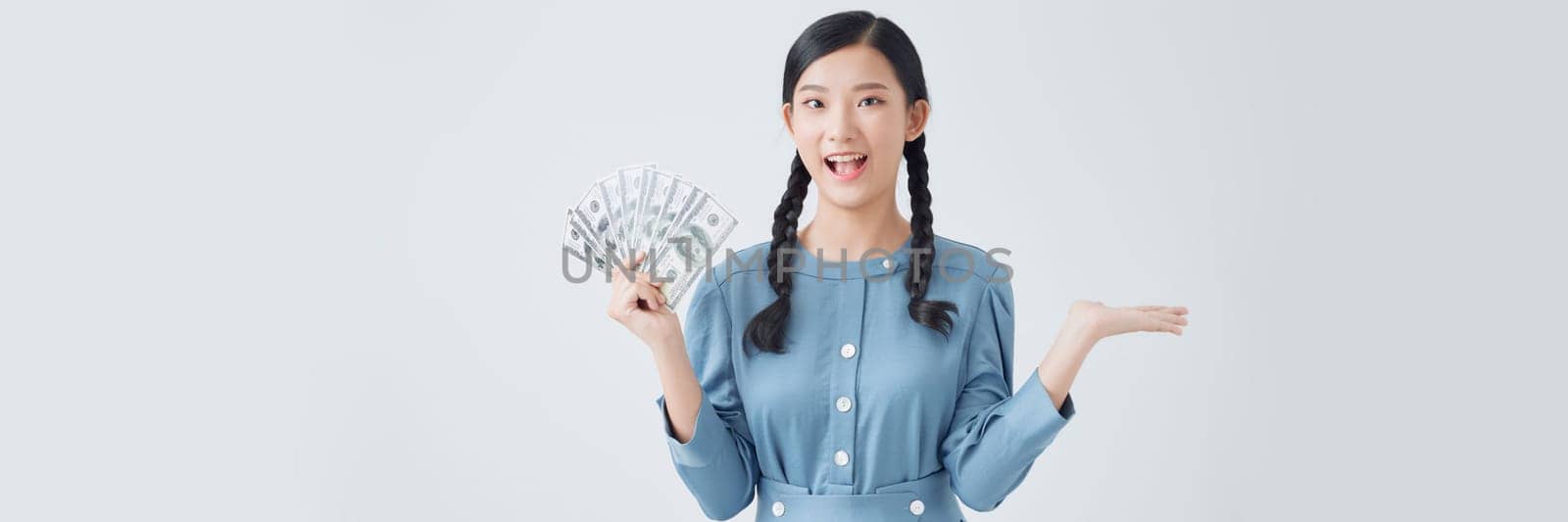 Attractive cheerful girl holding demonstrating fan cash salary income isolated over white background by makidotvn