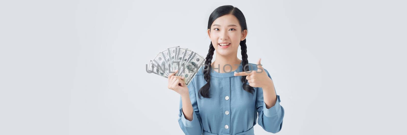 Funky millennial asian lady point money wear denim dress isolated on white background by makidotvn