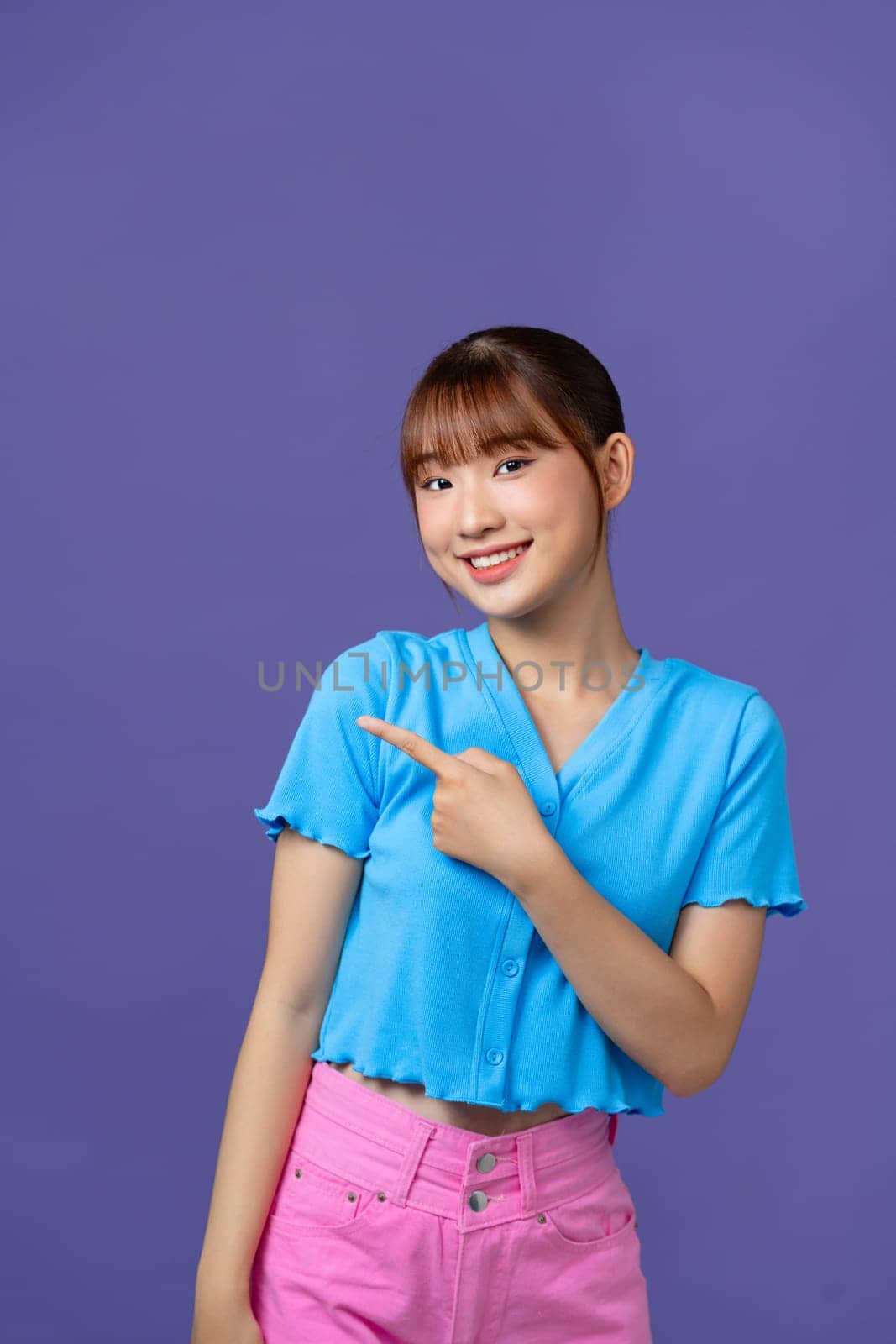 attractive cheerful girl demonstrating copy space ad new isolated over purple background